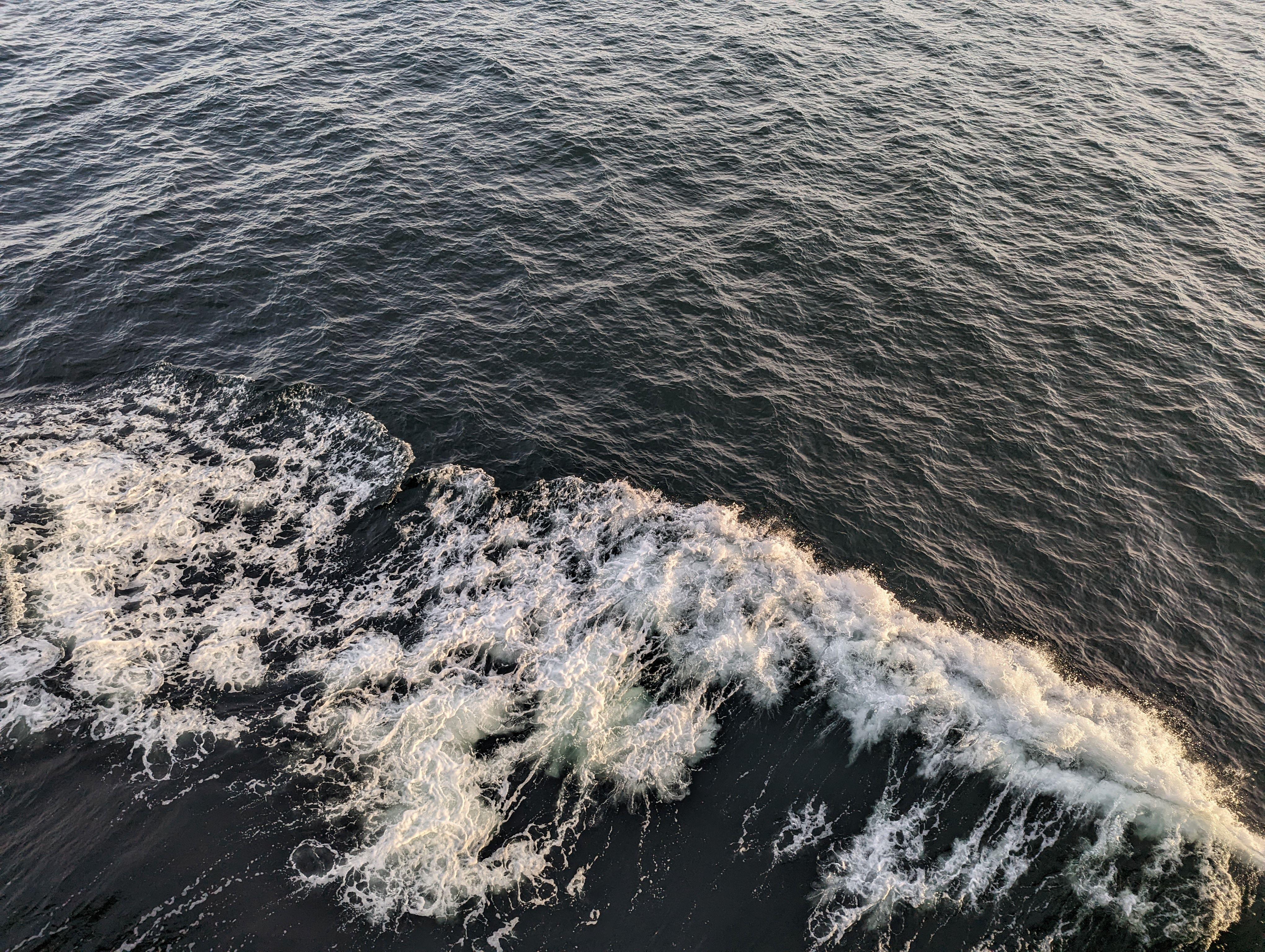 Top-down view of ocean waves and ripples creating foam. Ideal for nature themes.