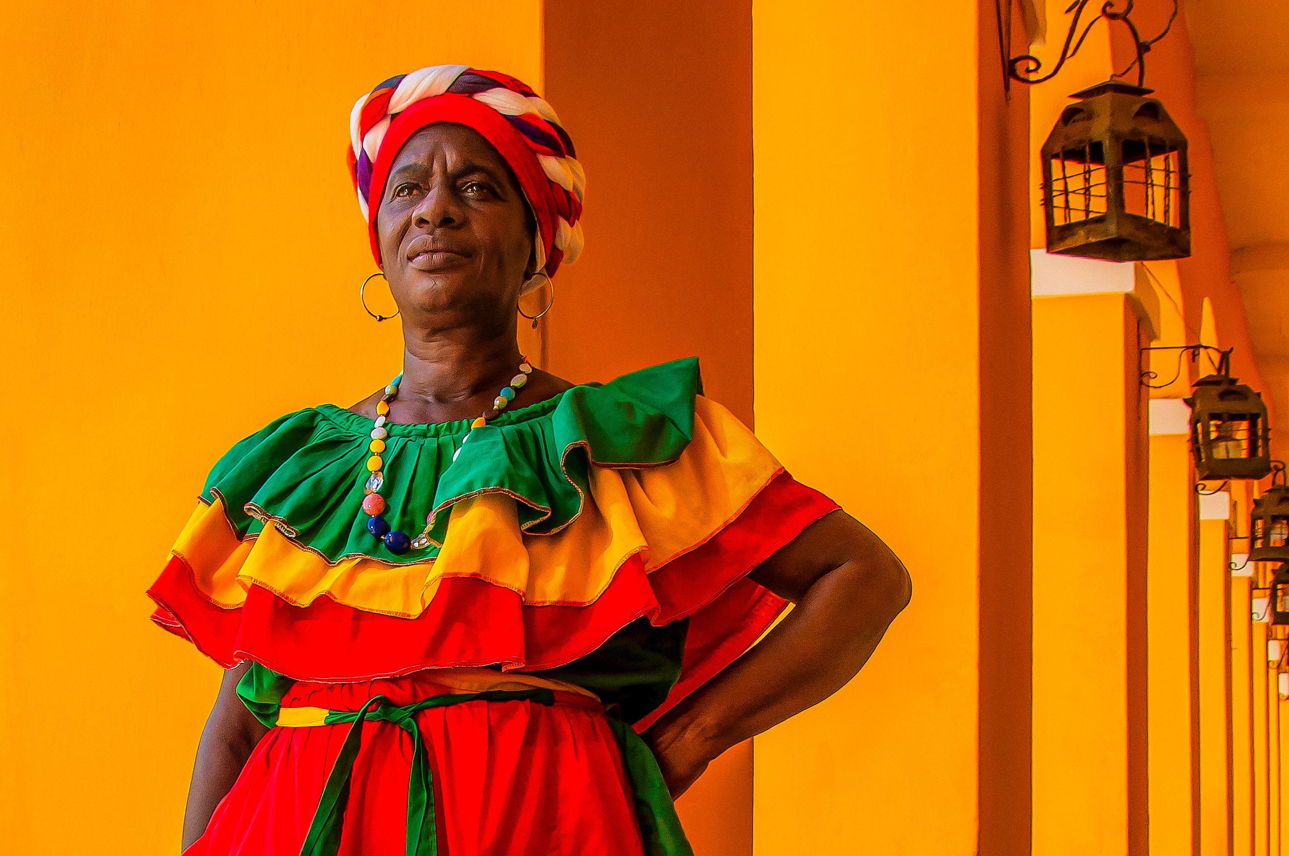 Colorful portrait of a woman in traditional attire against a lively backdrop in Cartagena, Colombia.