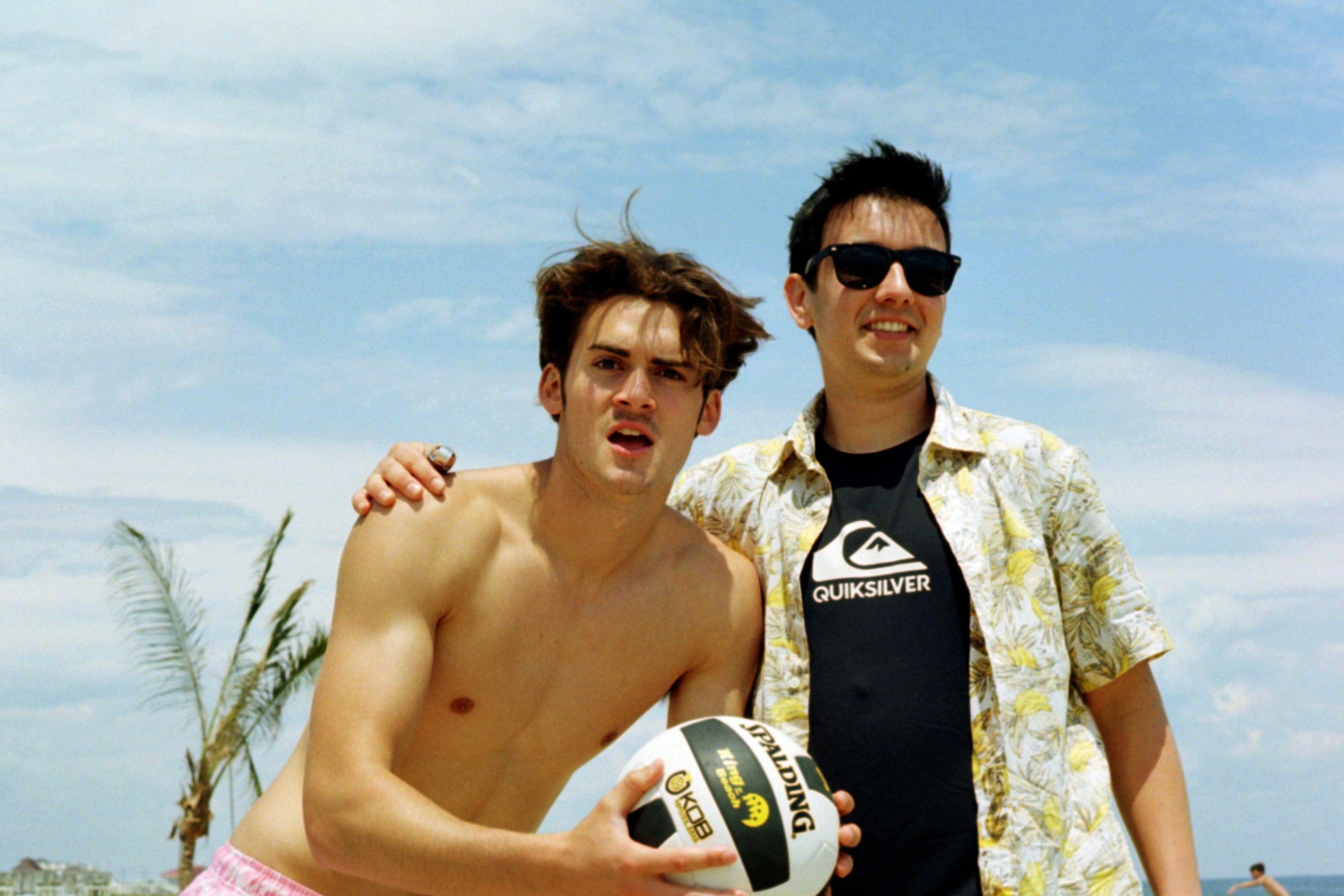 Two young men enjoying a sunny day with a volleyball at Sea Bright beach, NJ.