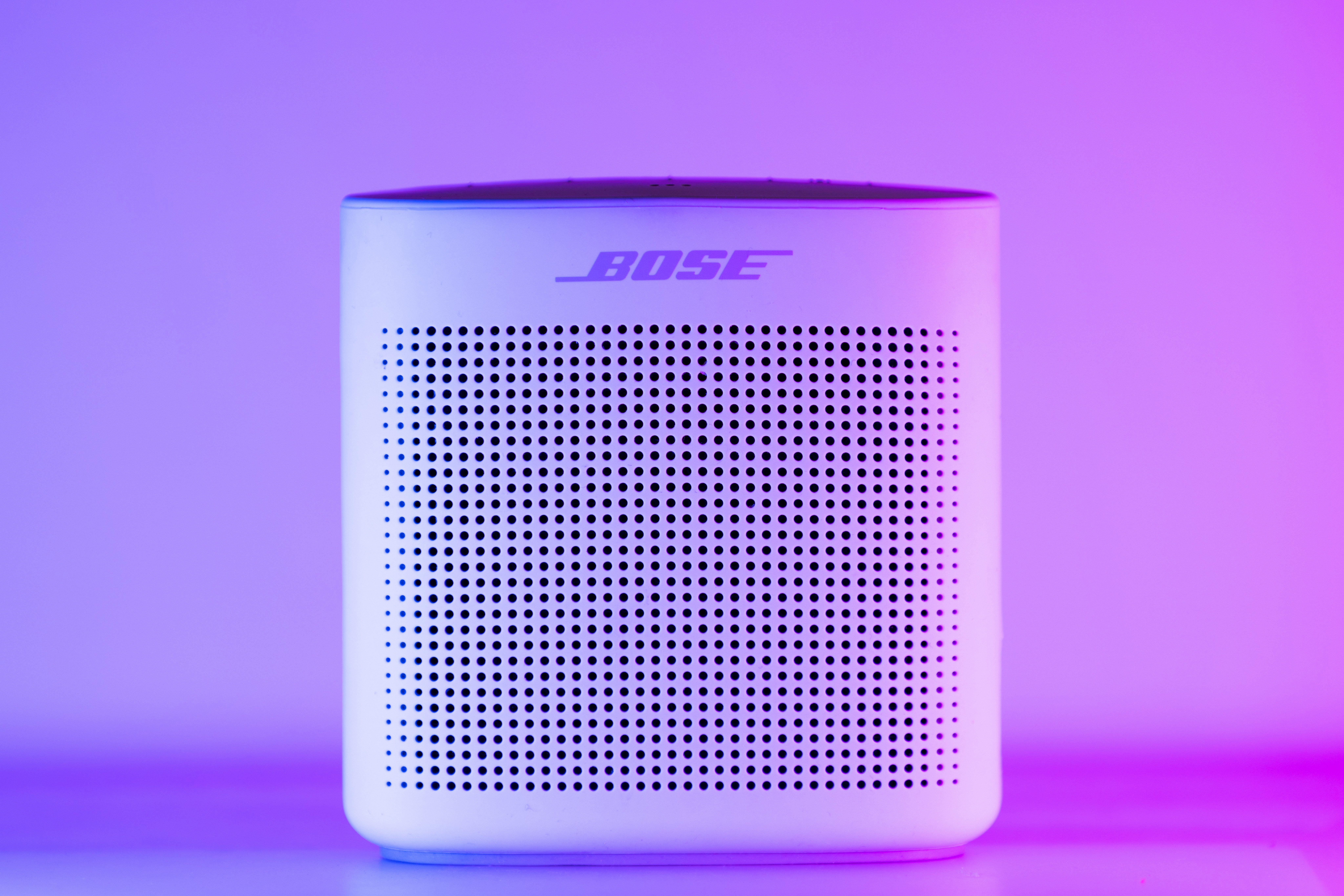 A sleek, modern Bluetooth speaker with a purple and blue light gradient, perfect for home audio setups.
