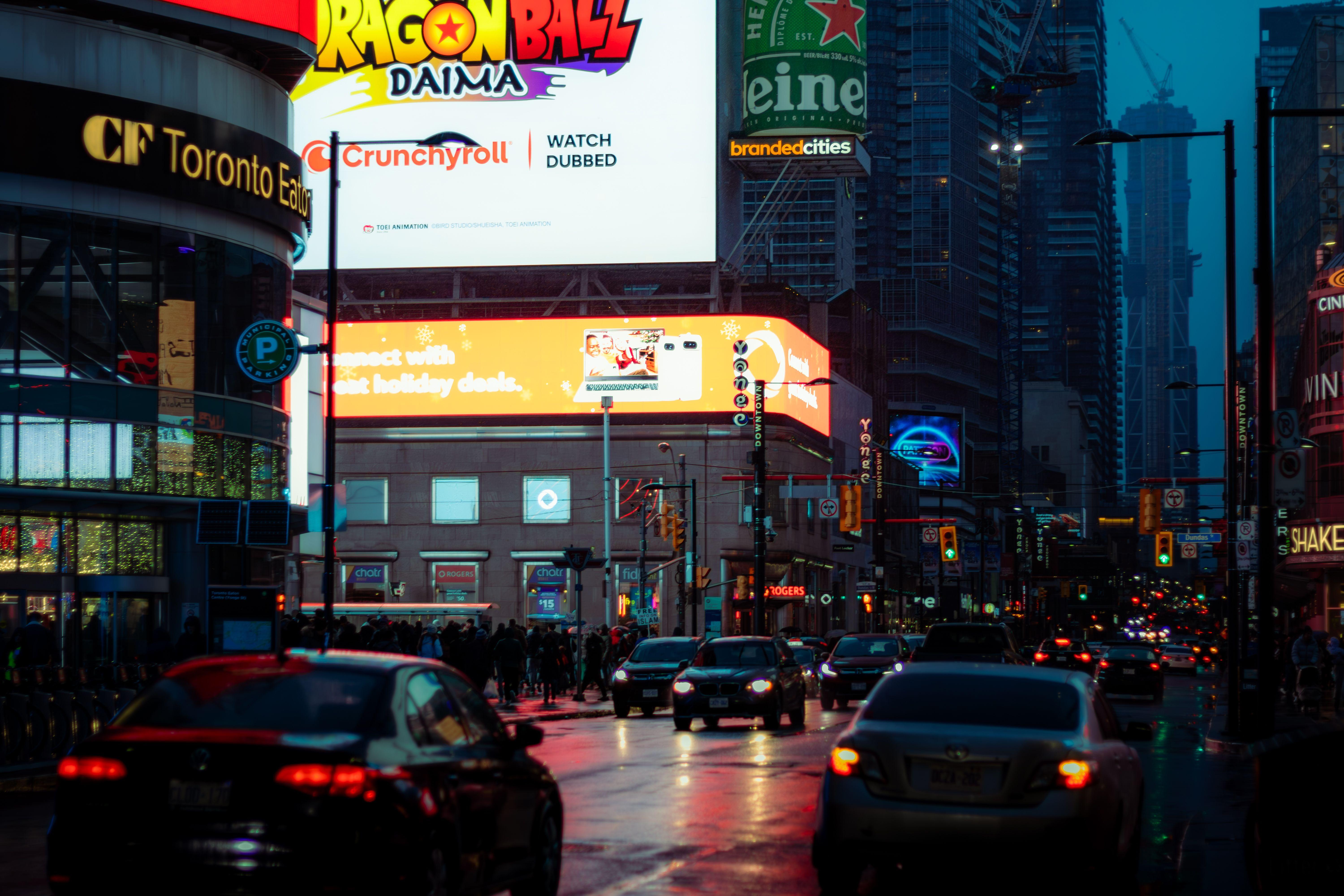 Dynamic city street scene in Toronto with vibrant billboards and bustling traffic.