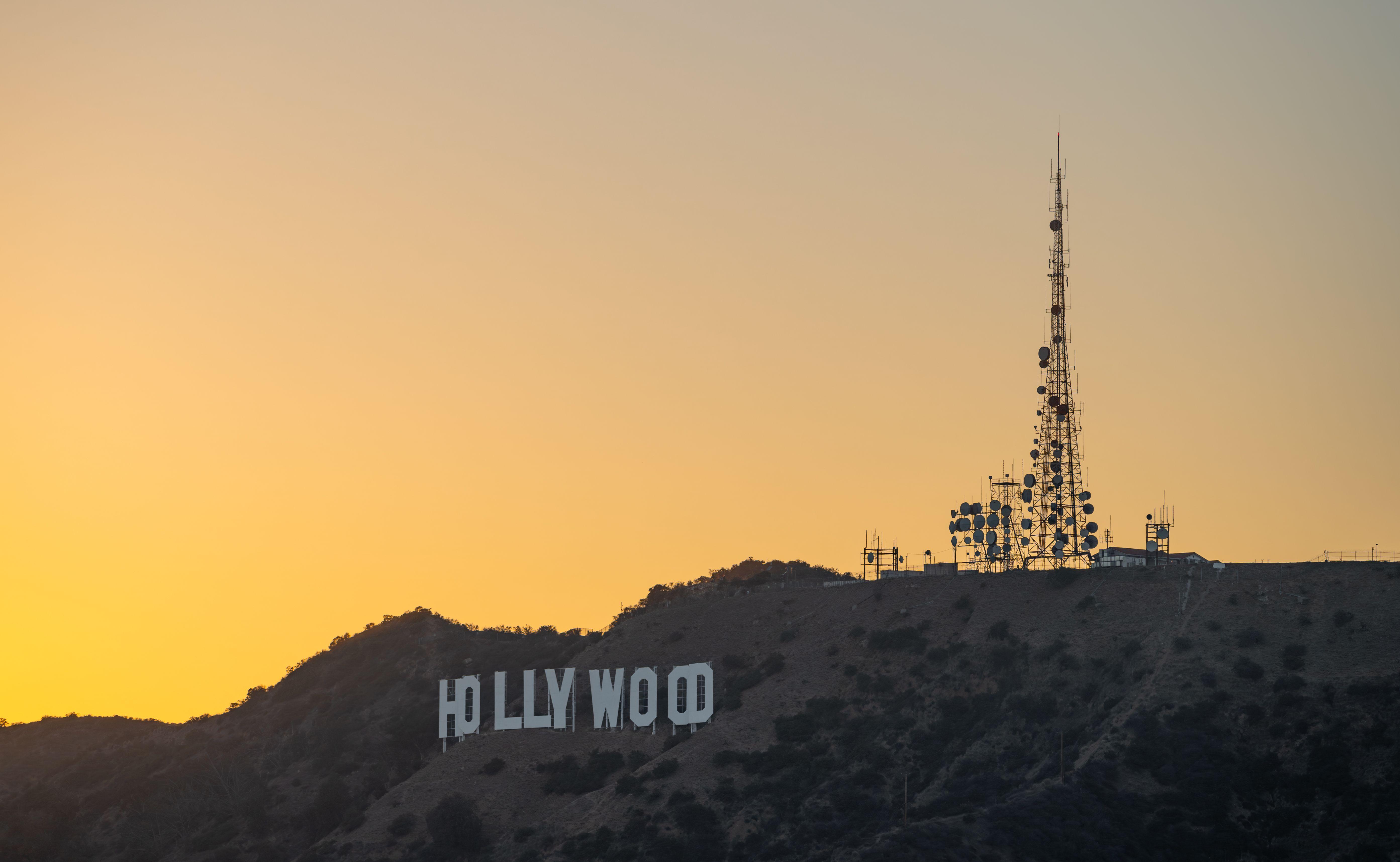 The iconic Hollywood sign captured at sunset, Los Angeles skyline in silhouette.