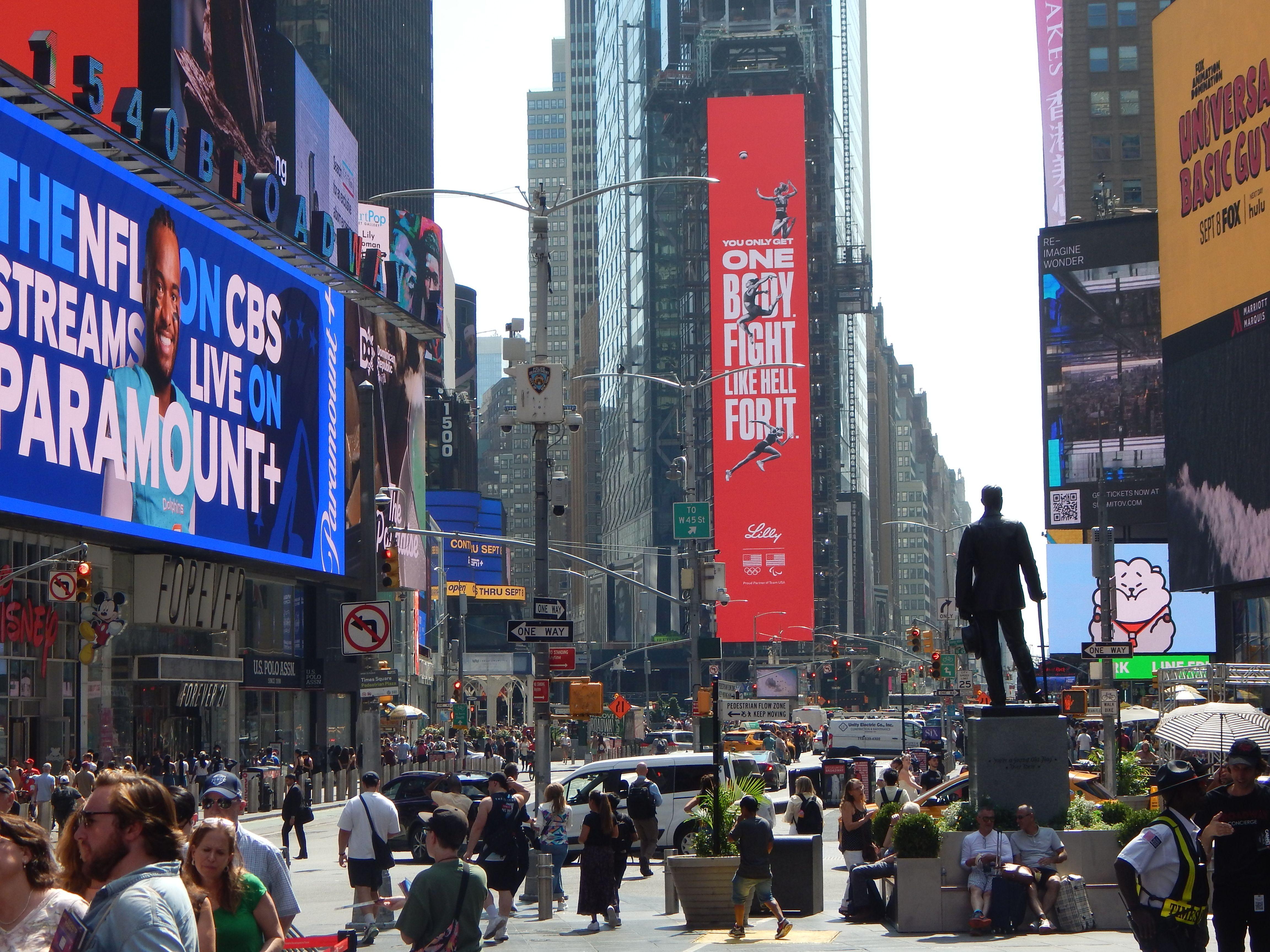 A vibrant scene of Times Square in New York City filled with billboards and crowds of people.