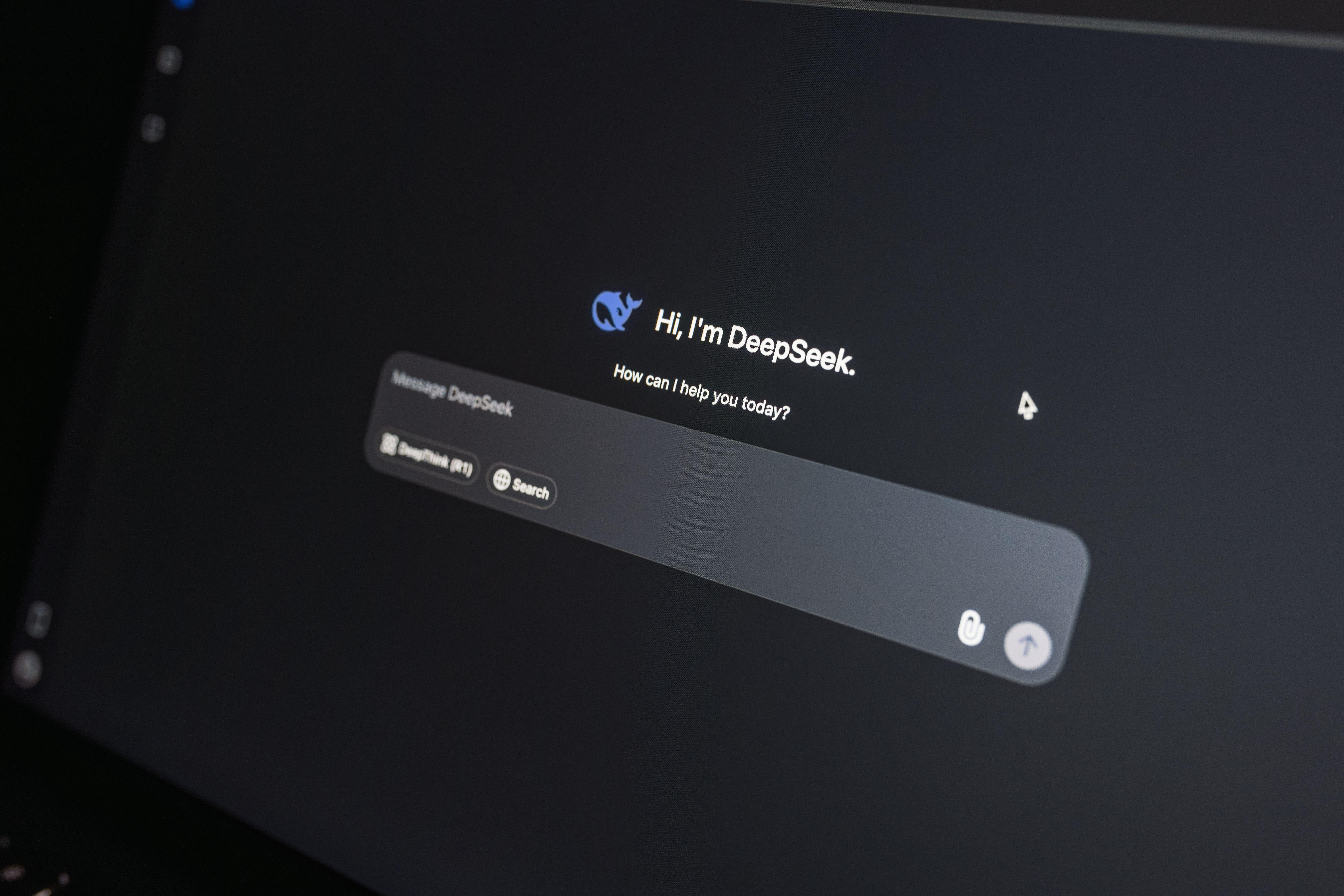 Close-up of DeepSeek AI chat interface on a laptop screen in low light.