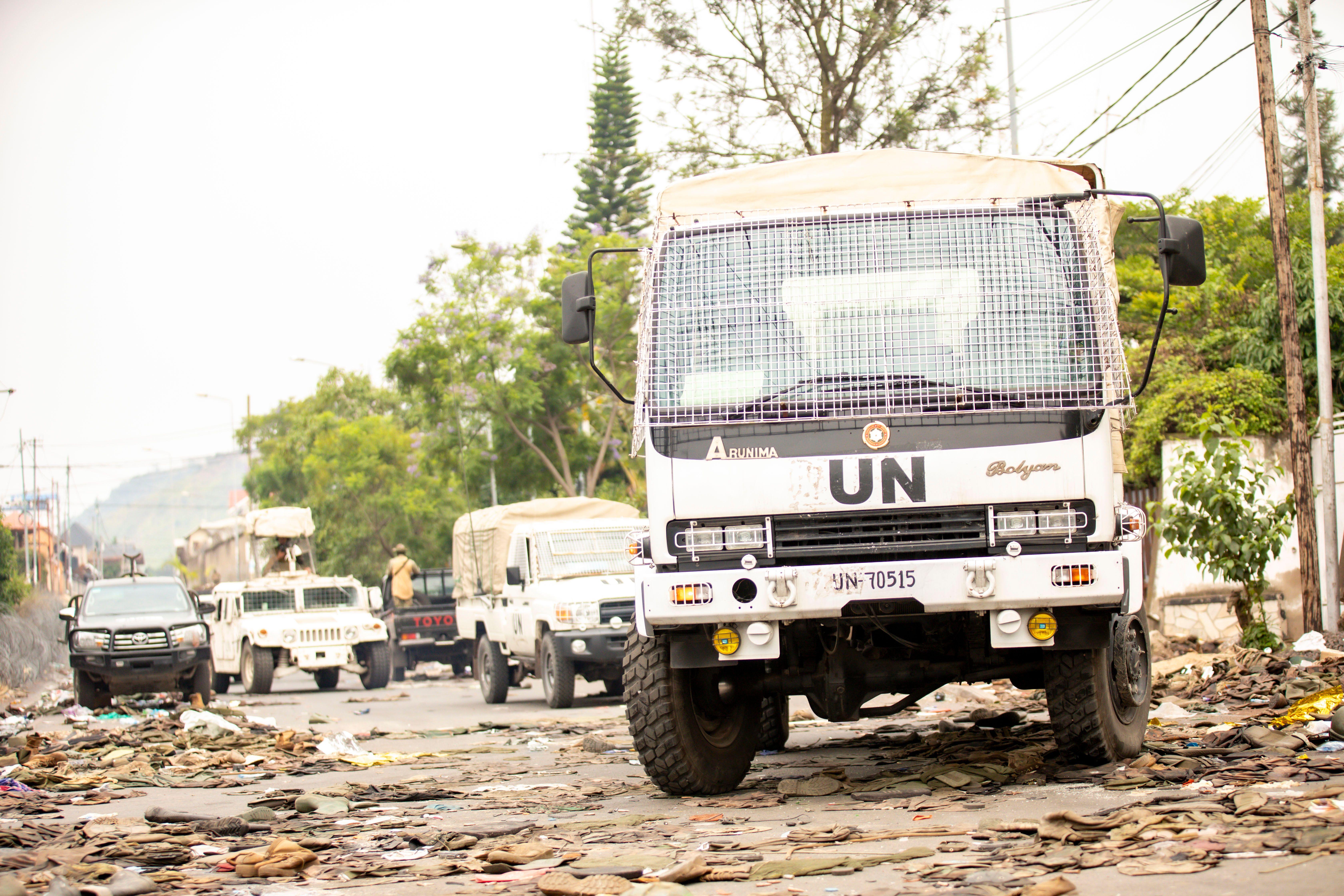 UN vehicles parked on a debris-covered road amid humanitarian efforts.