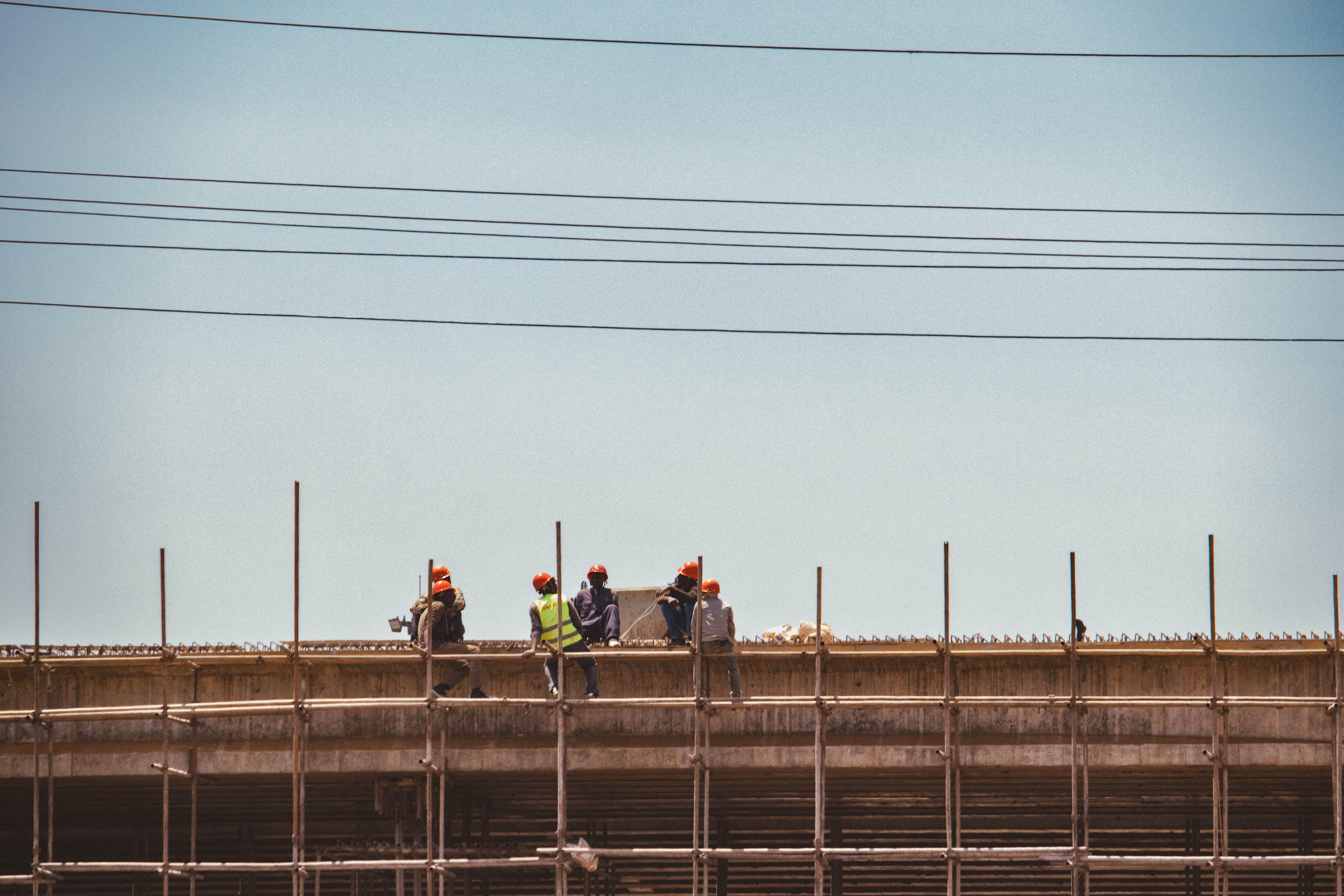 Construction workers on scaffold against a clear sky in Nairobi, Kenya.