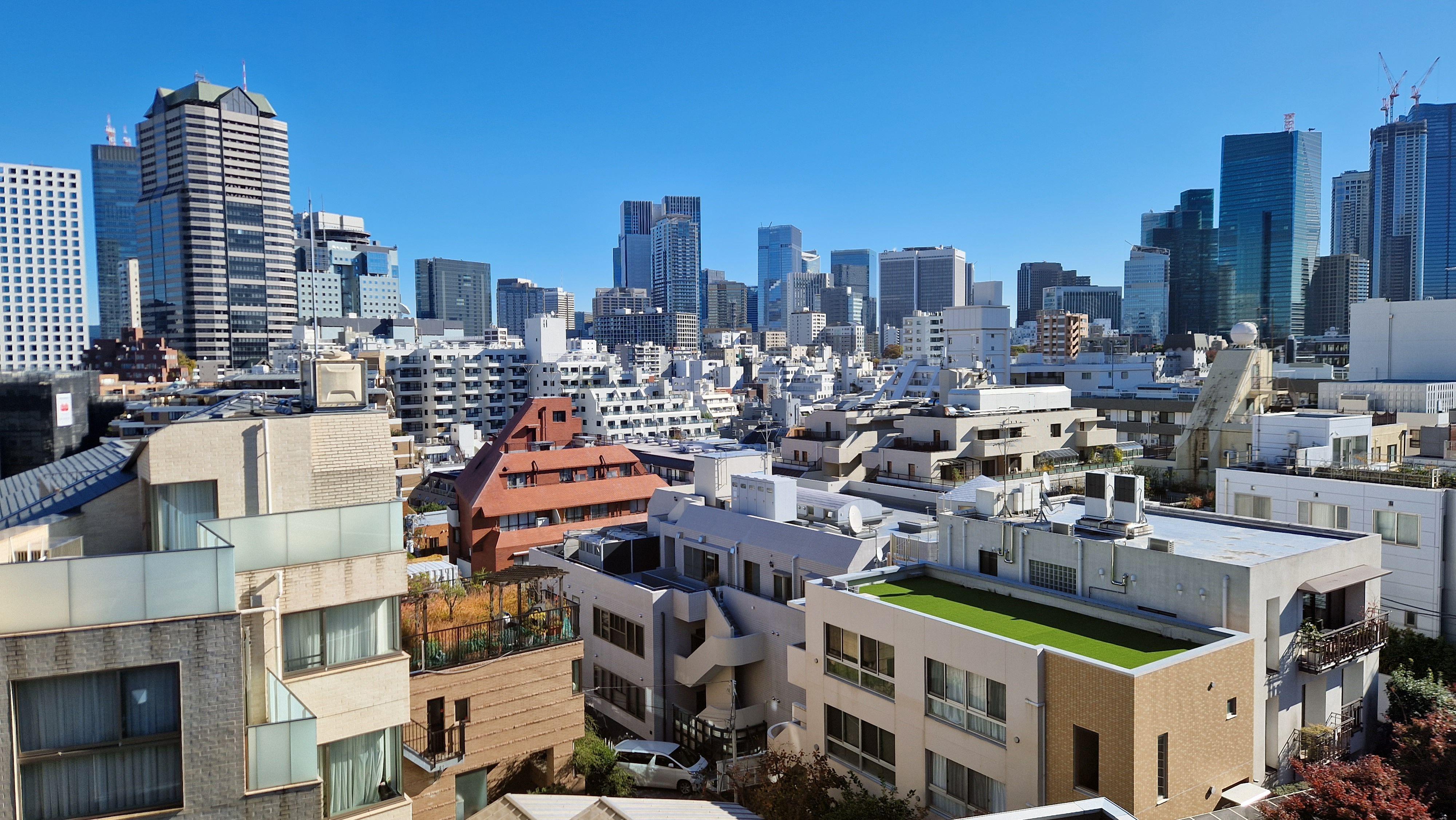 A clear view of Tokyo's modern skyline under a bright blue sky.