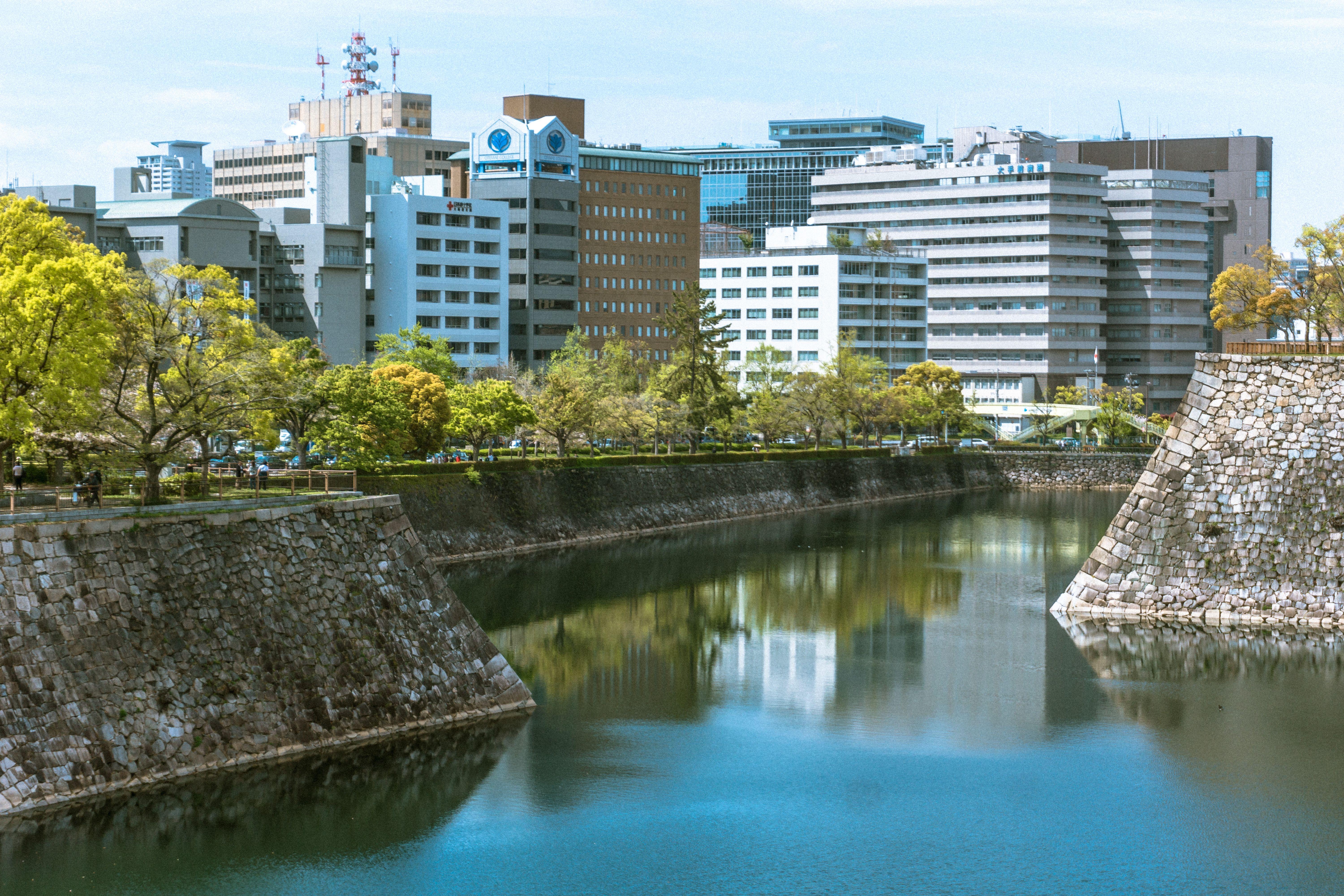 City skyline reflected in a moat surrounded by greenery. Featured in the modern Japanese cityscape.
