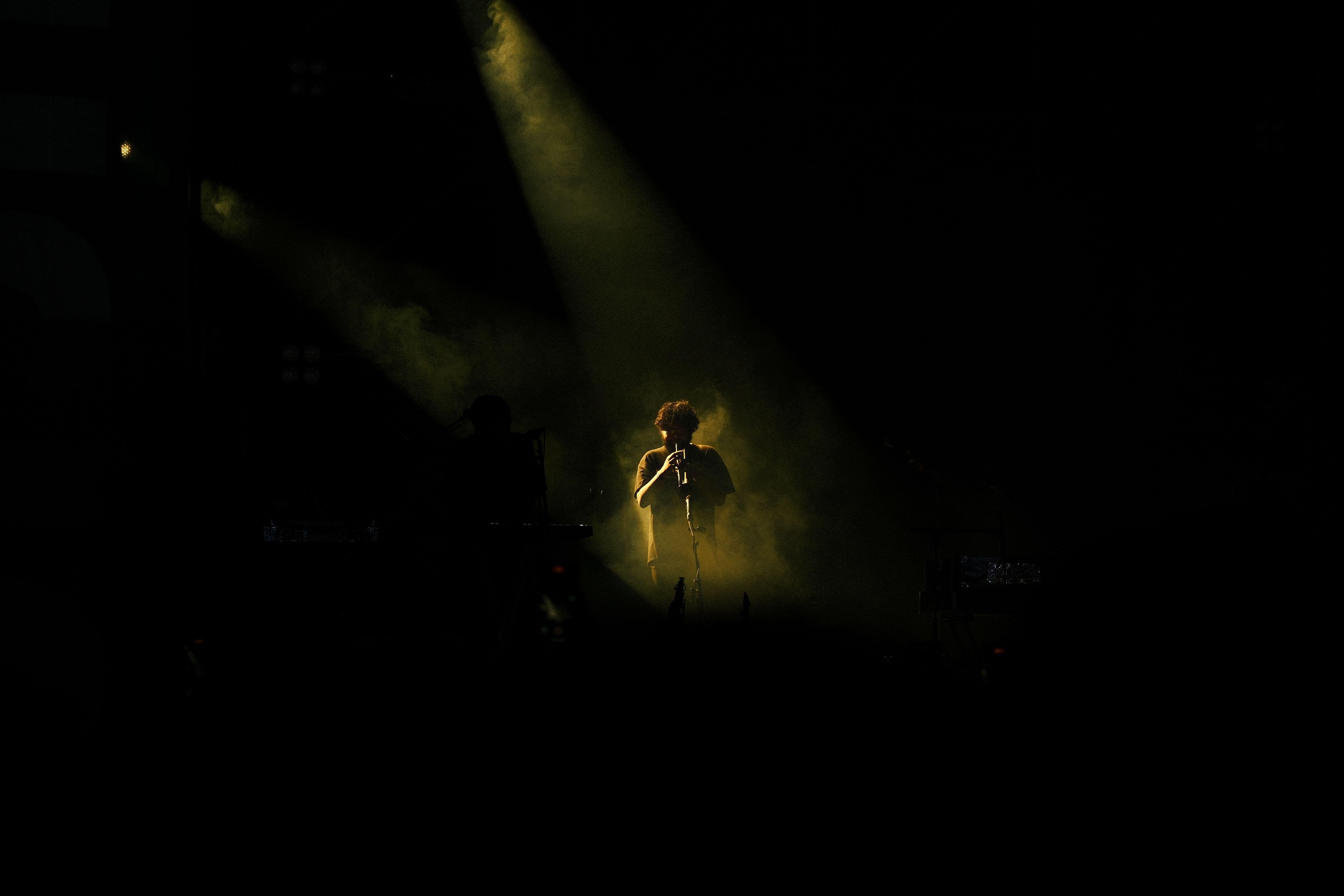 Captivating concert scene featuring a flute player under dramatic stage lighting.