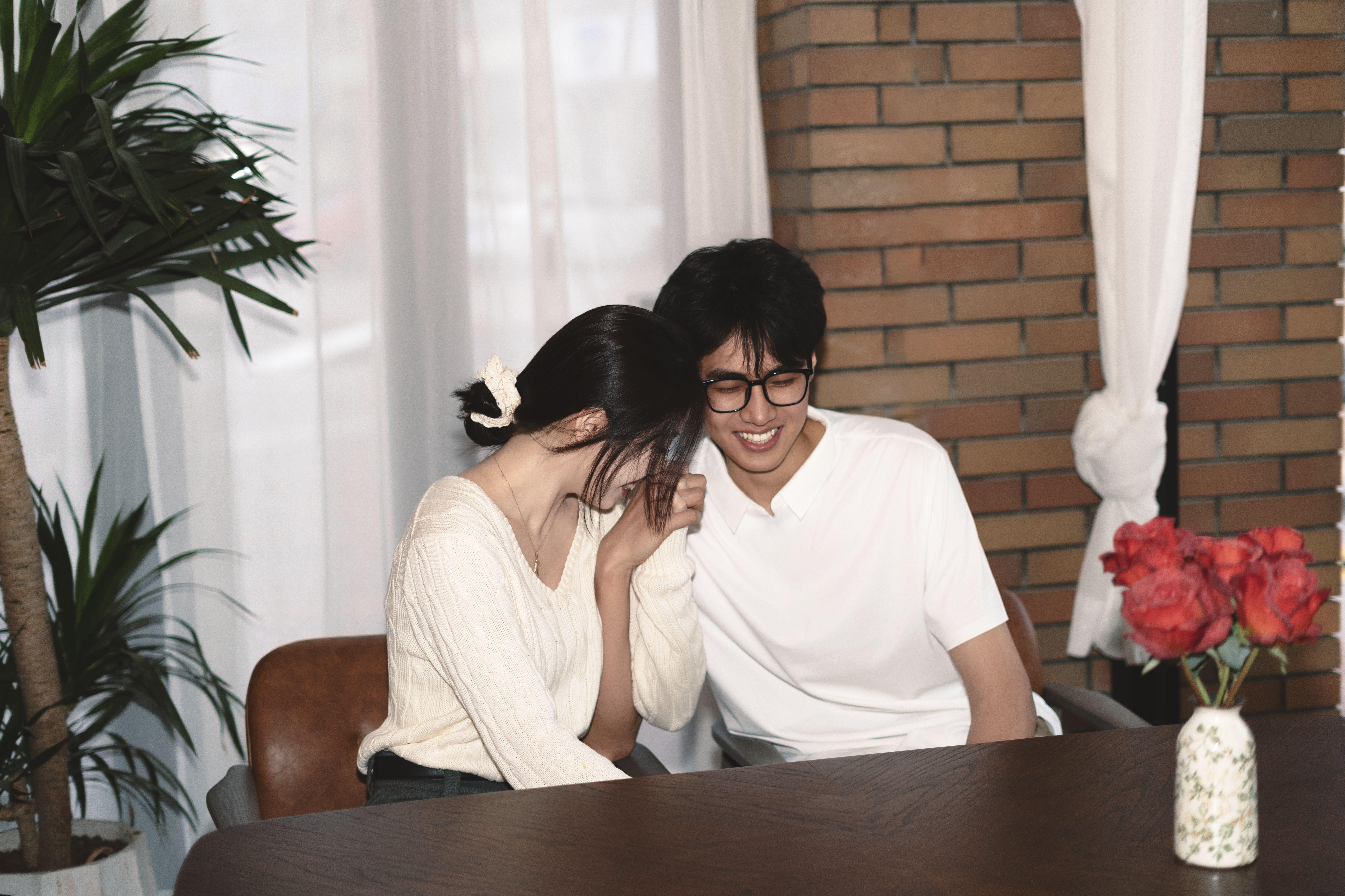 Couple enjoying a cozy moment in a stylish indoor setting with natural light.
