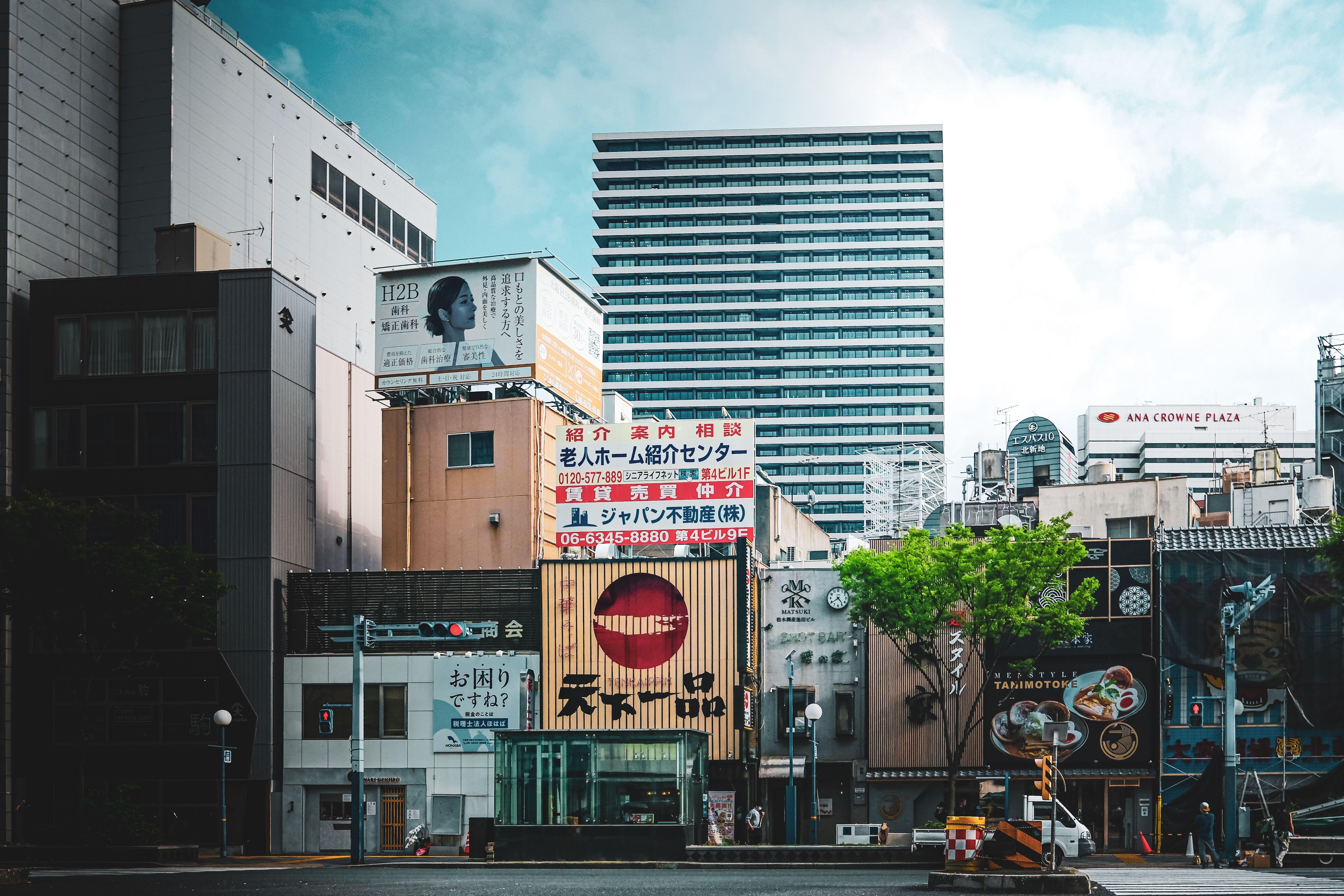 Vibrant city view with modern architecture and advertisement signs, showcasing urban life.