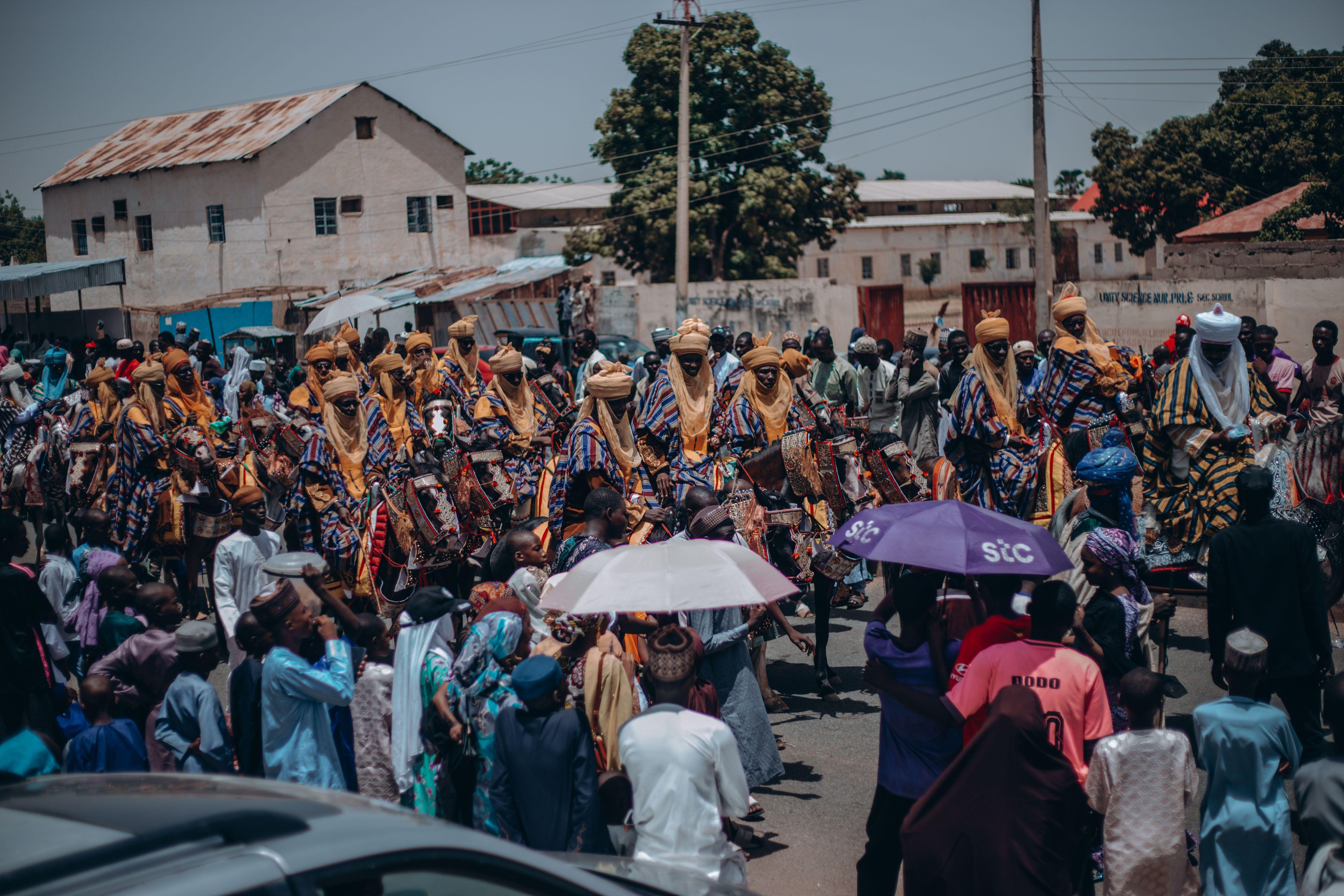 Colorful parade with riders in traditional attire celebrating Nigerian culture.
