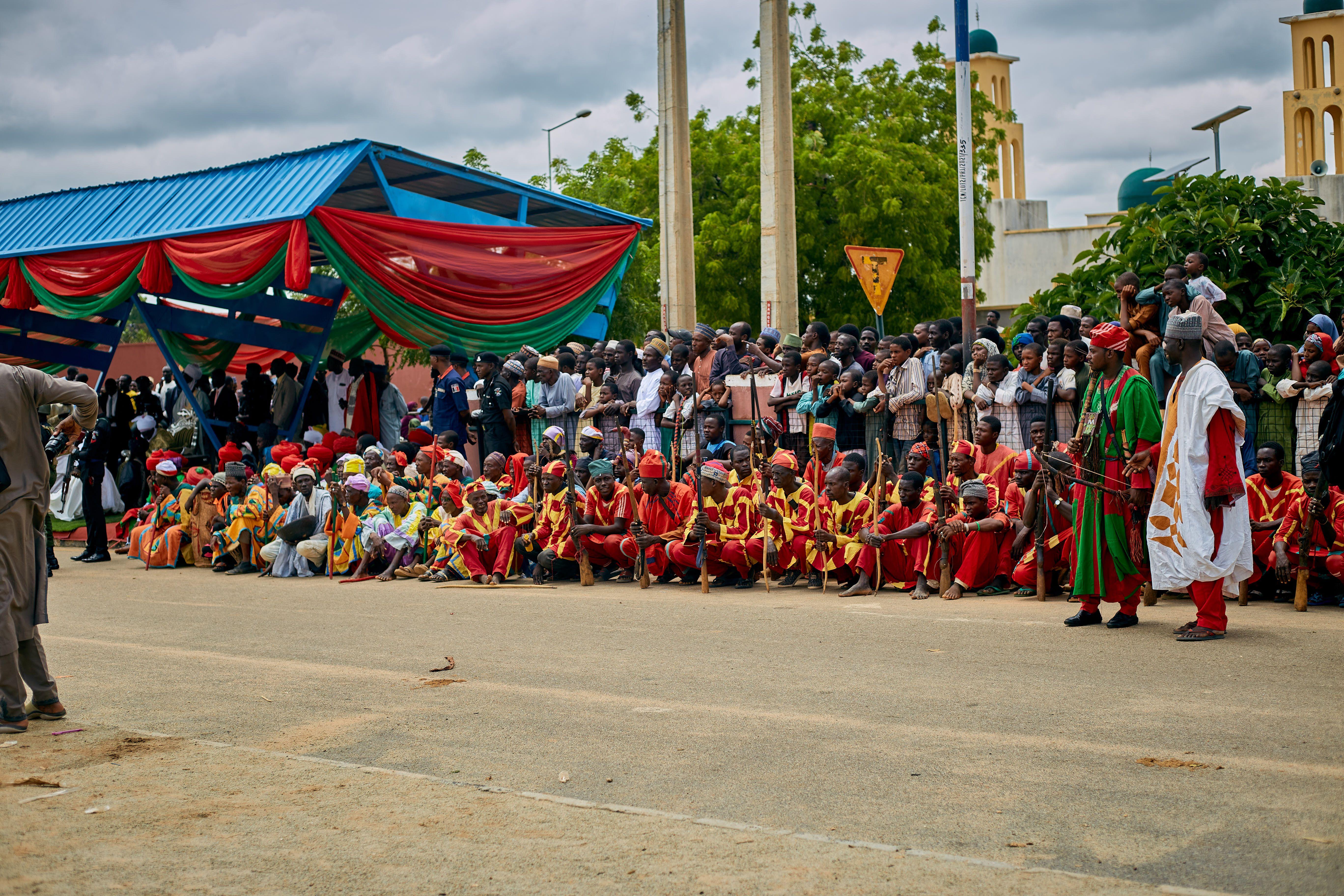 Vibrant street parade with traditional attire and crowd in Nigeria.
