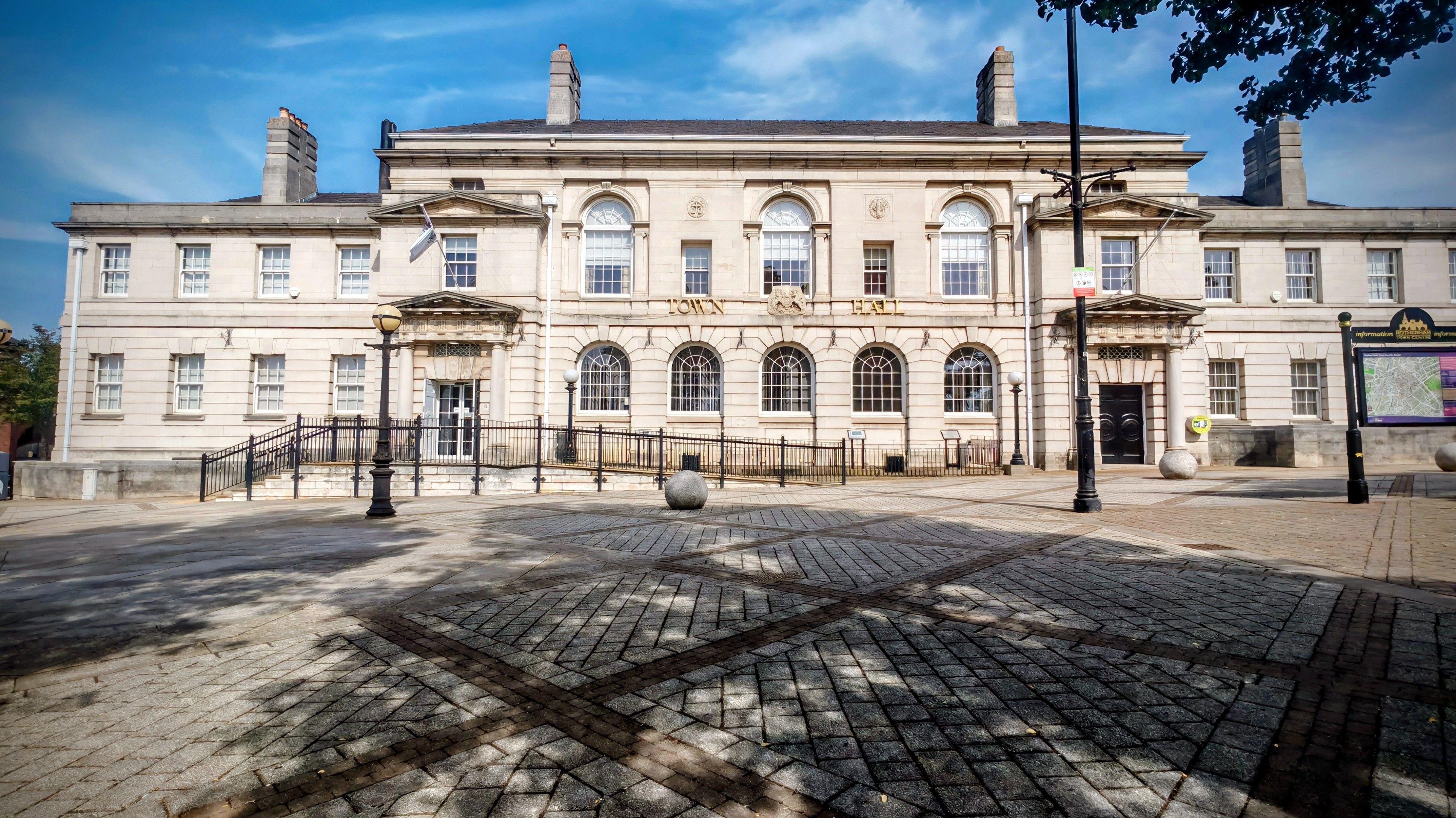 Historic town hall with classic architecture under a bright blue sky.