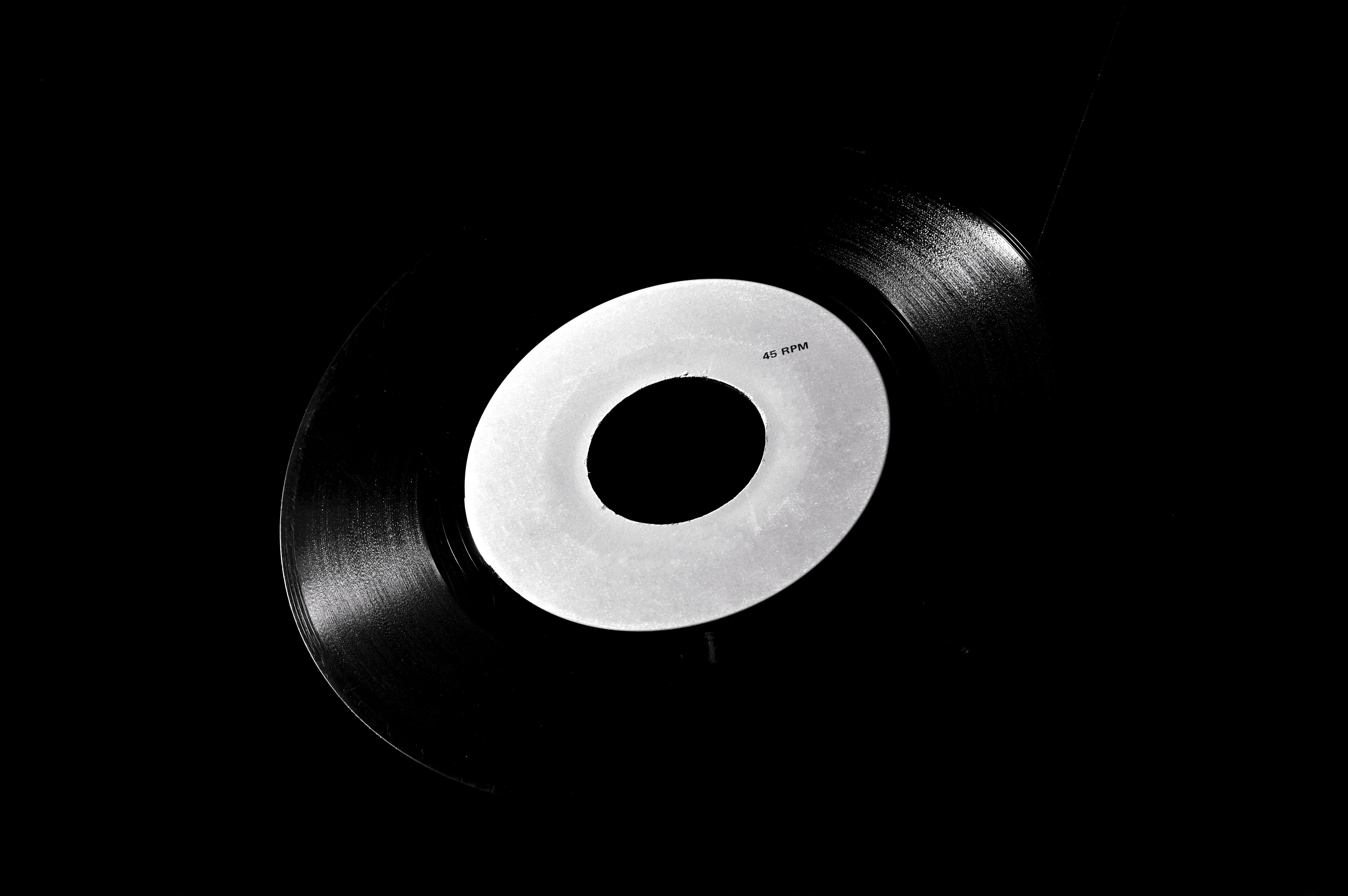 Classic black vinyl record with a white label on a dark background, symbolizing retro music nostalgia.