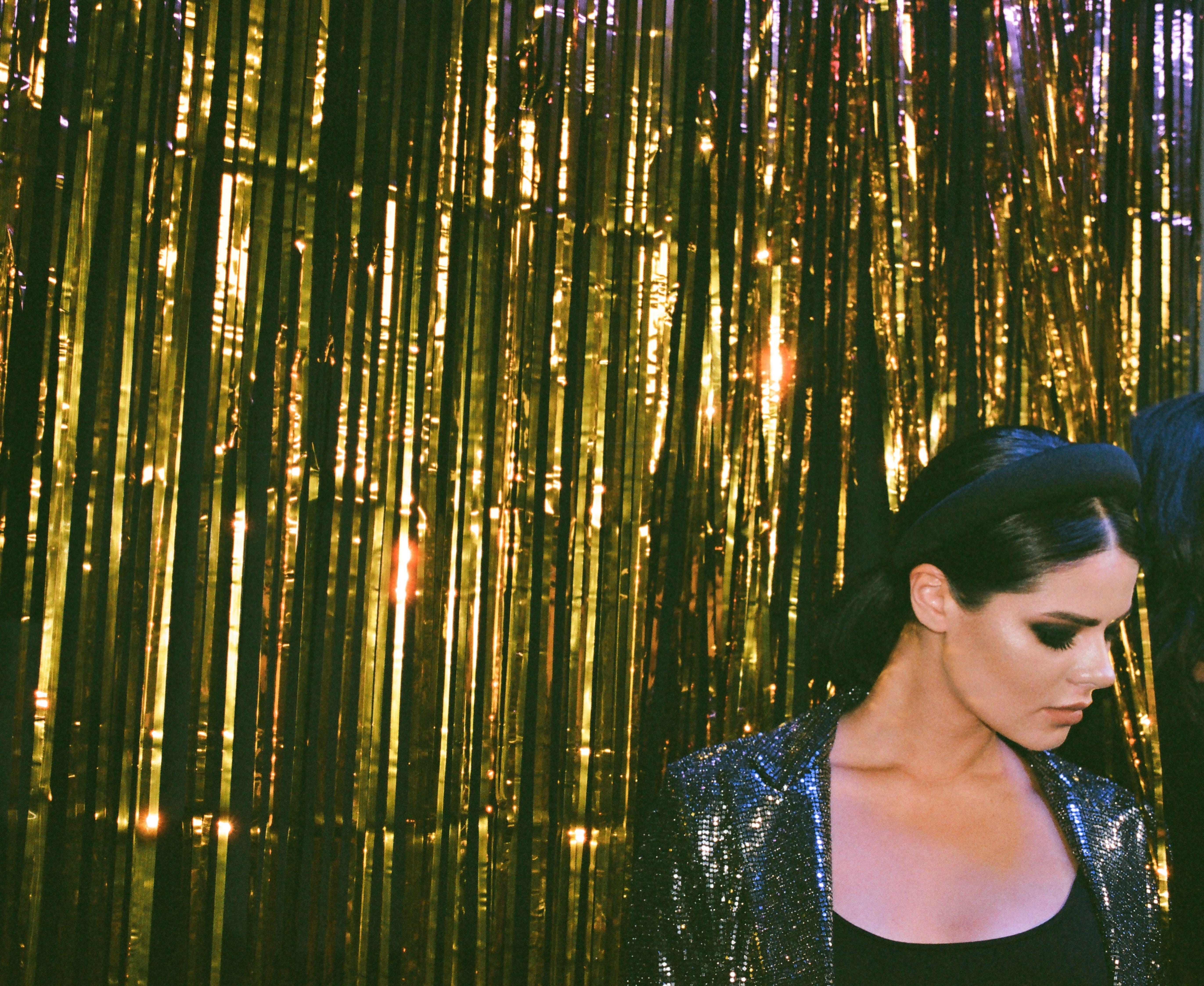 A stylish woman in sparkling attire at a glamorous New Year's Eve celebration.