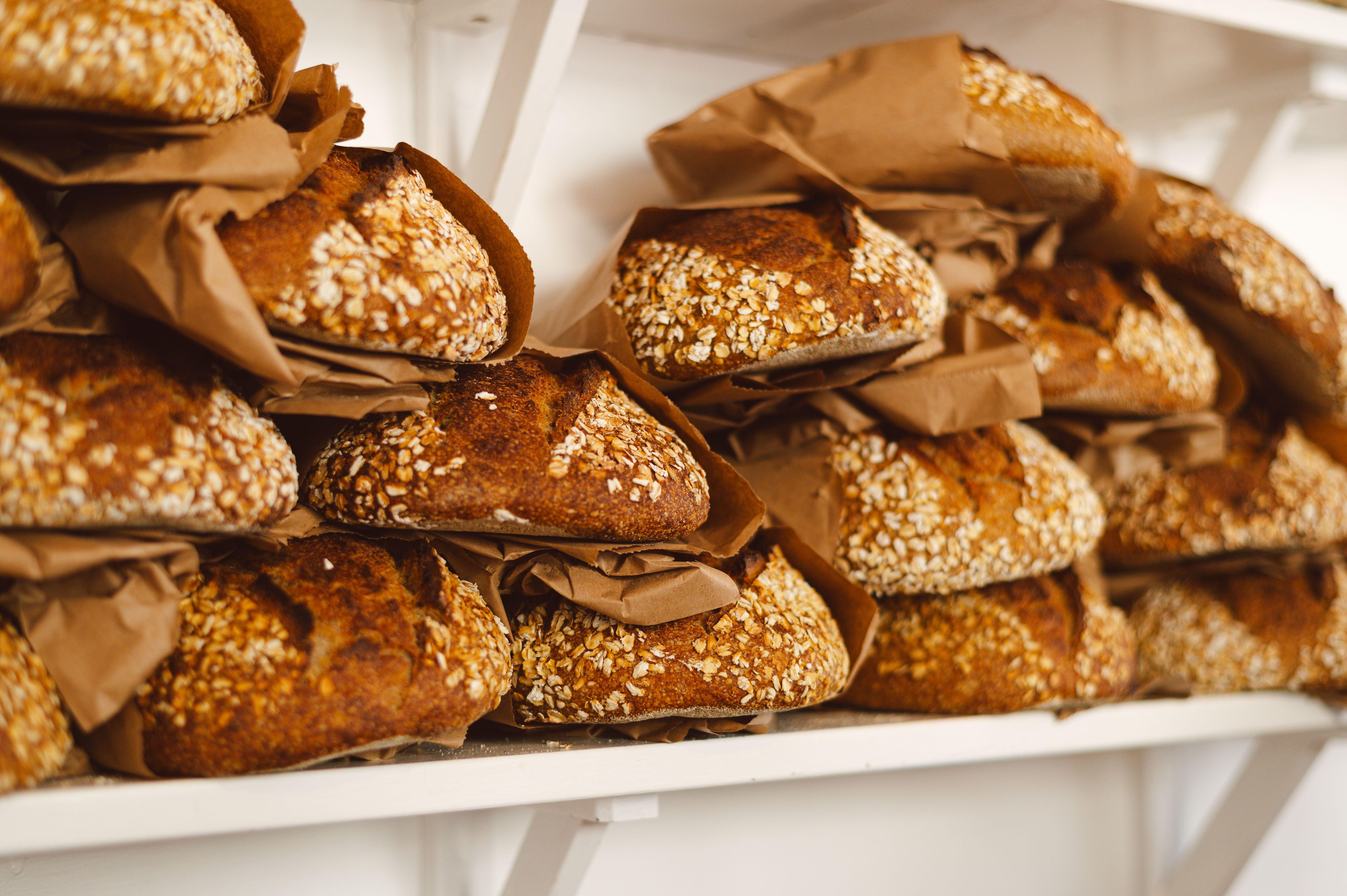 Freshly baked sourdough loaves stacked on shelves in a Dunkeld bakery.