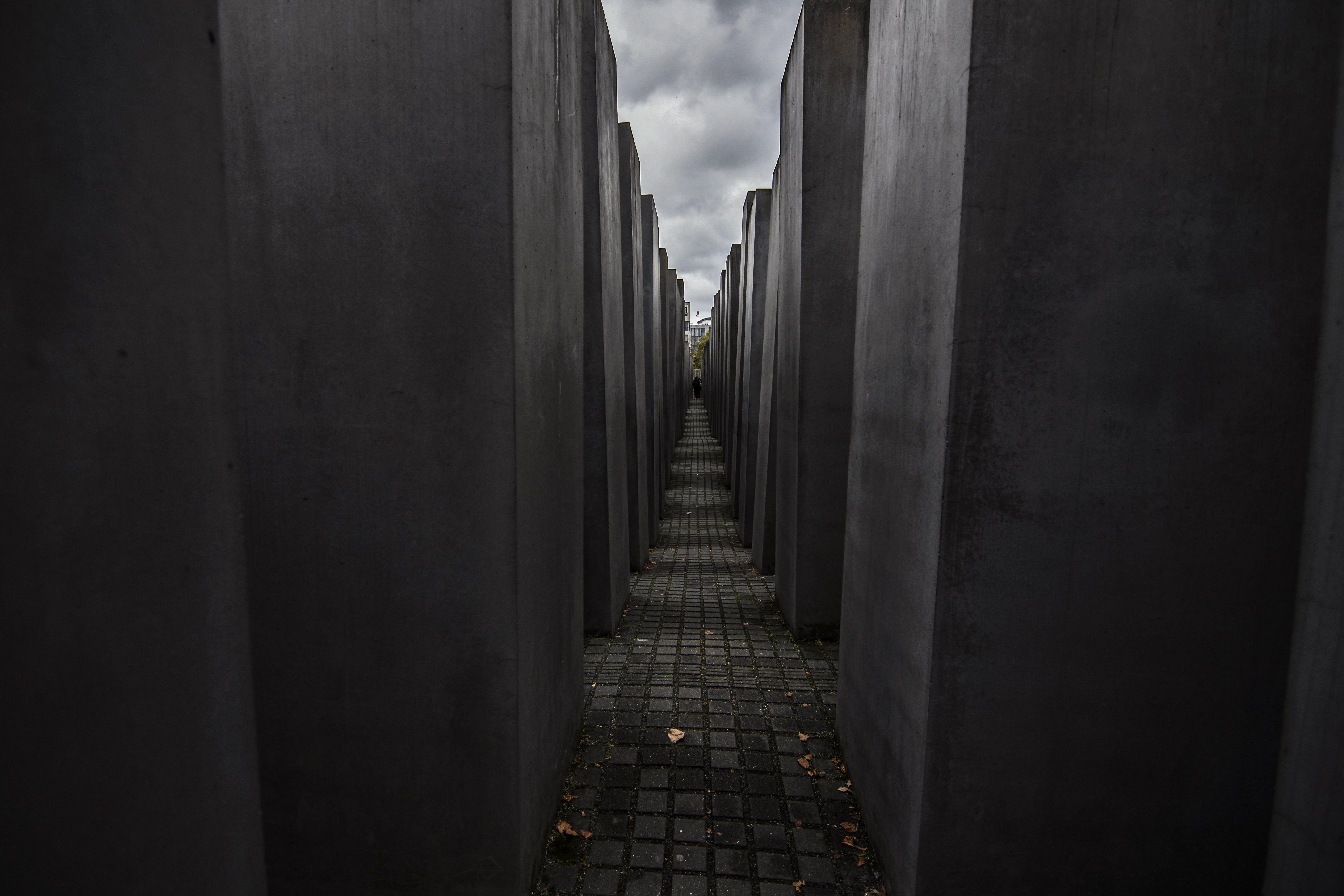 Dramatic view of the Holocaust Memorial in Berlin under a cloudy sky.