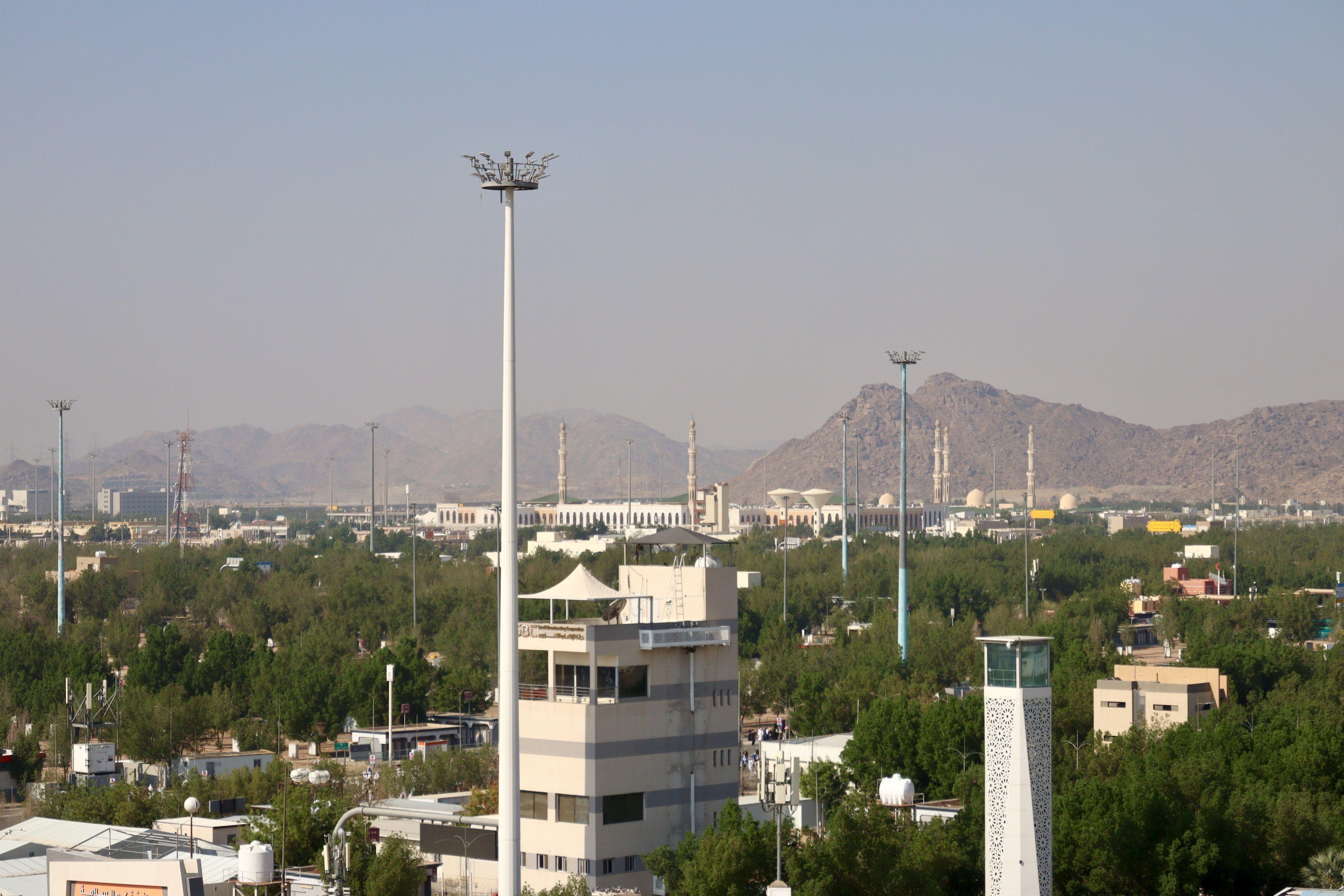 Aerial cityscape view featuring a mosque and mountains in Saudi Arabia.