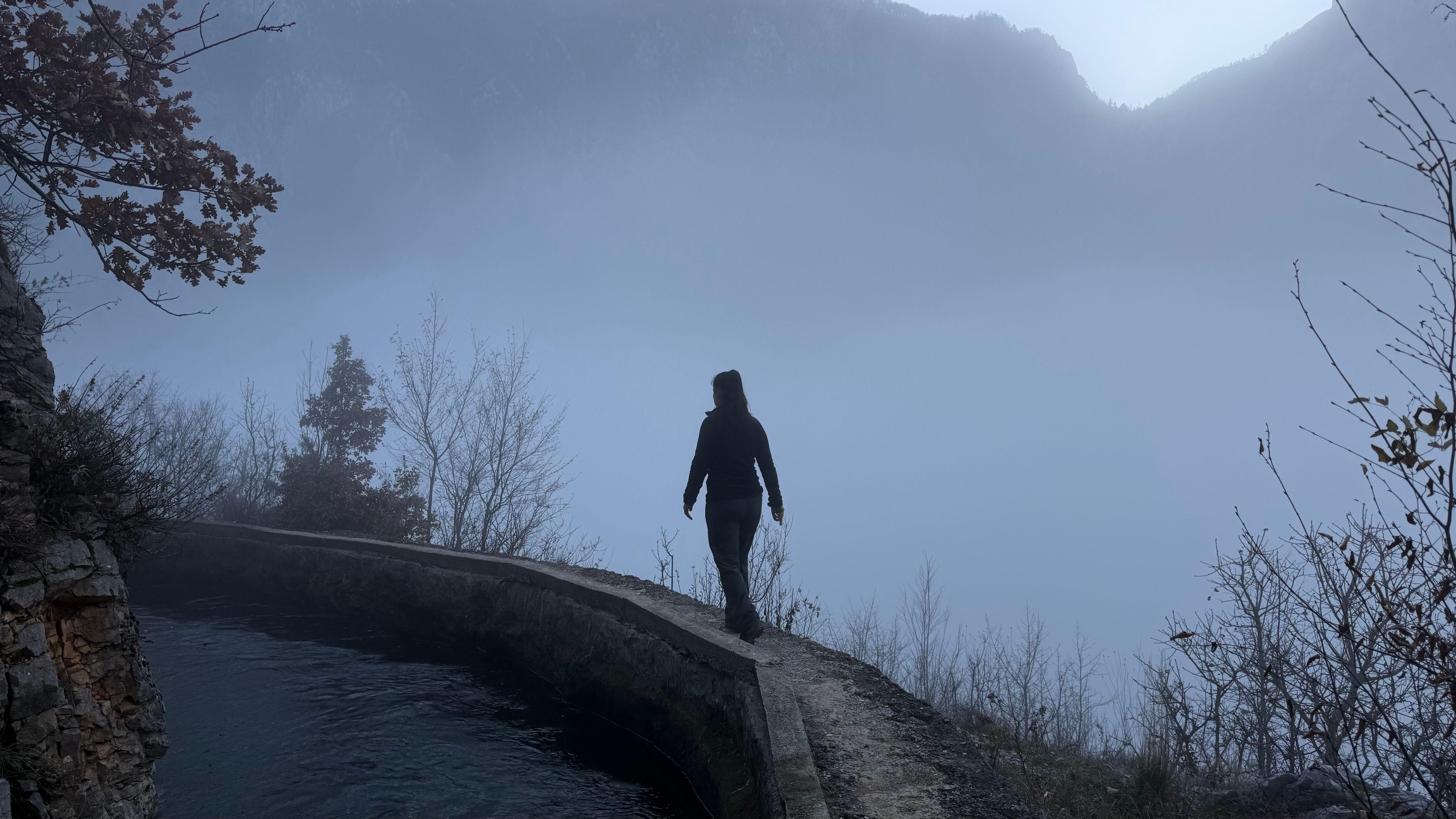 A solitary person walks along a misty mountain path in Dibër County, Albania.
