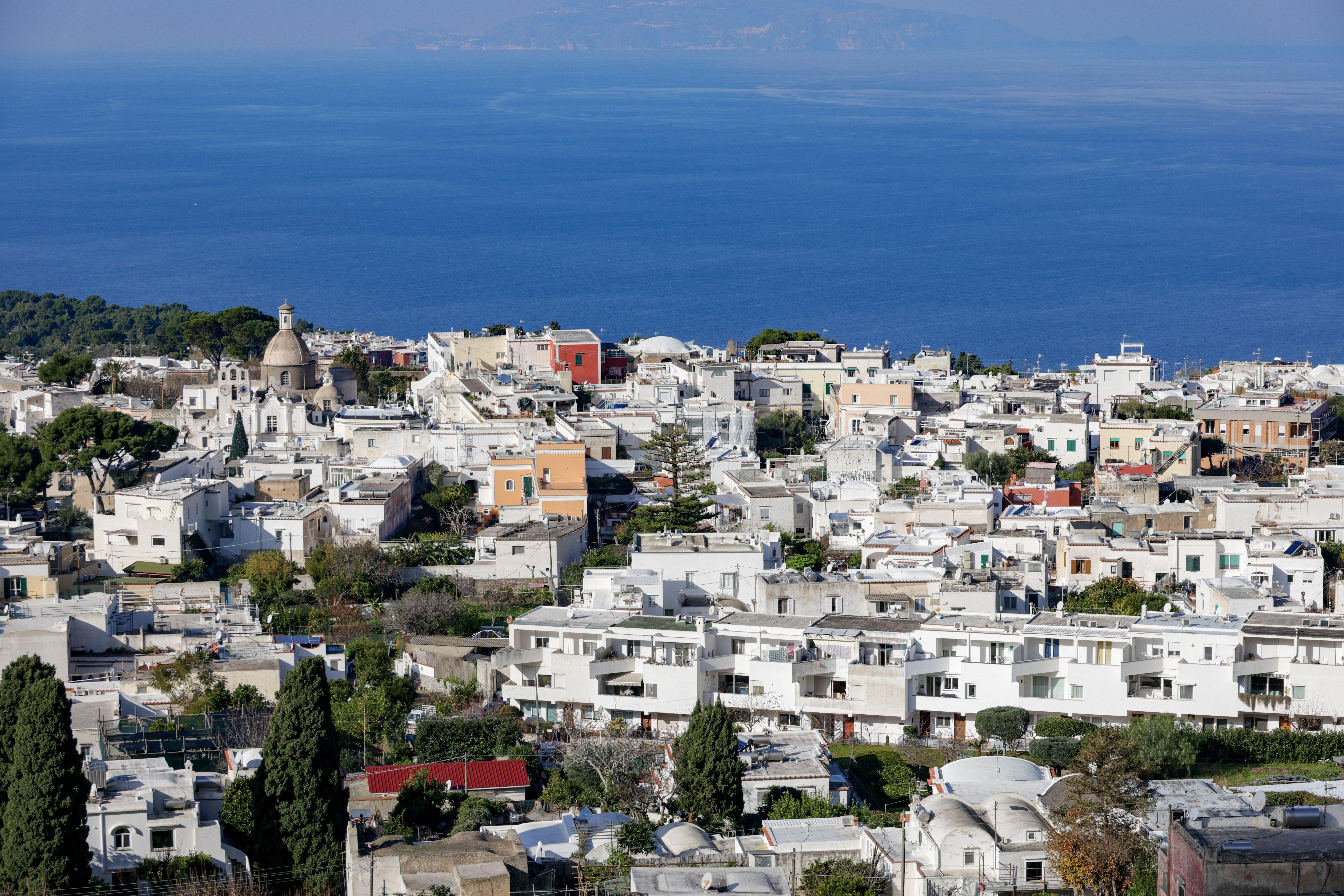Charming aerial view of Capri's whitewashed buildings and Mediterranean Sea.