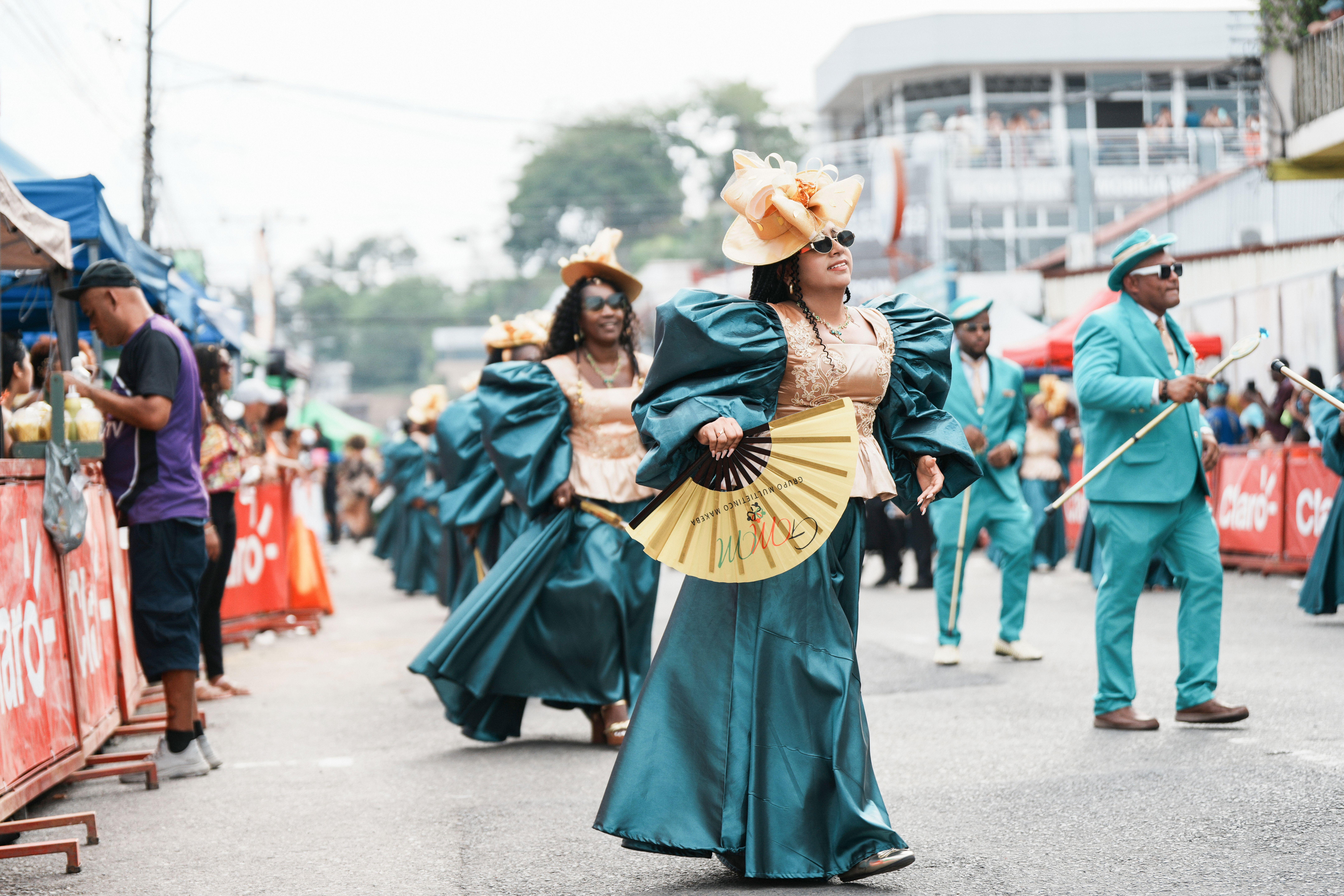 Vibrant parade with participants in colorful costumes marching in Limón, Costa Rica.