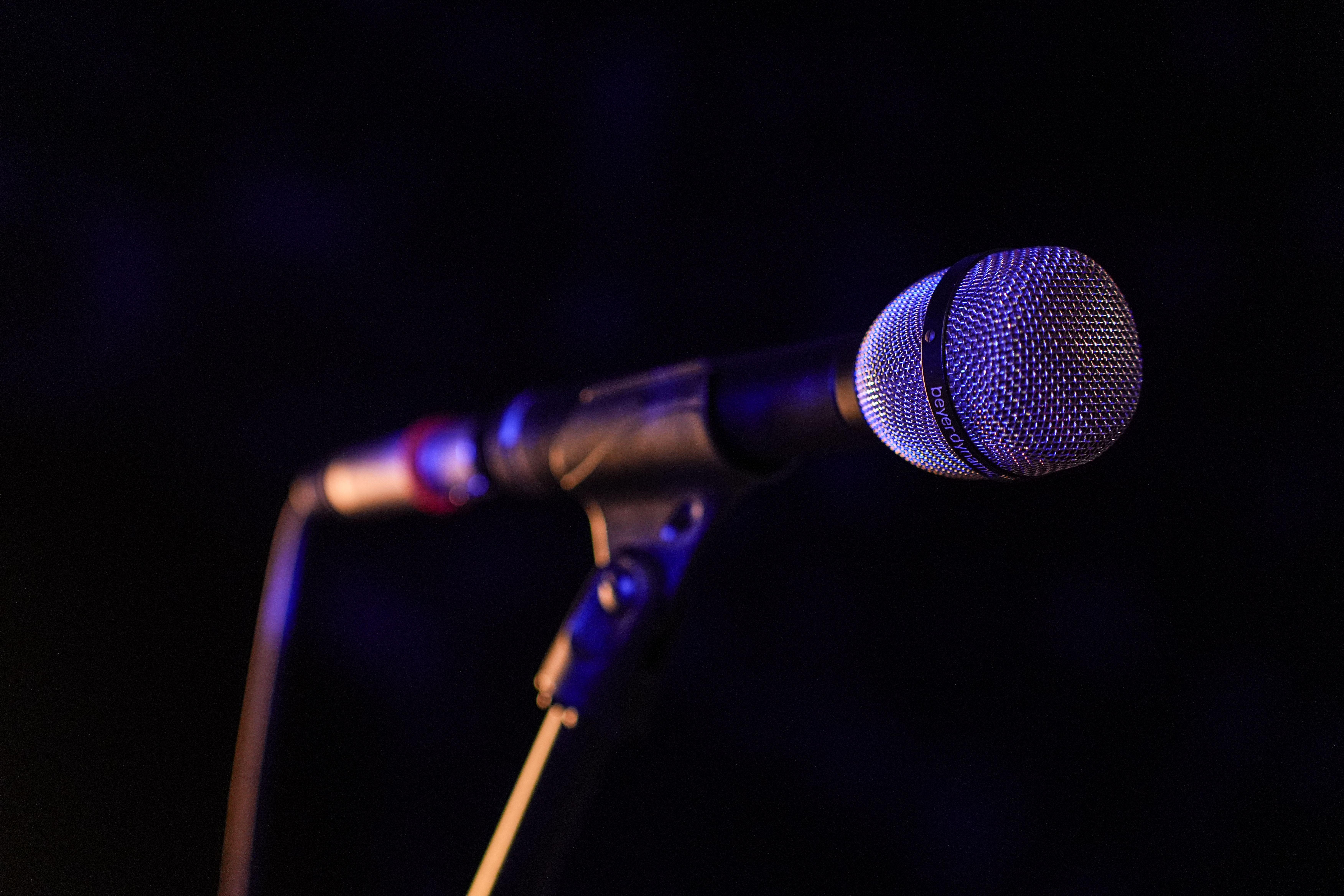 Close-up of a microphone set up on stage, highlighting concert ambiance.