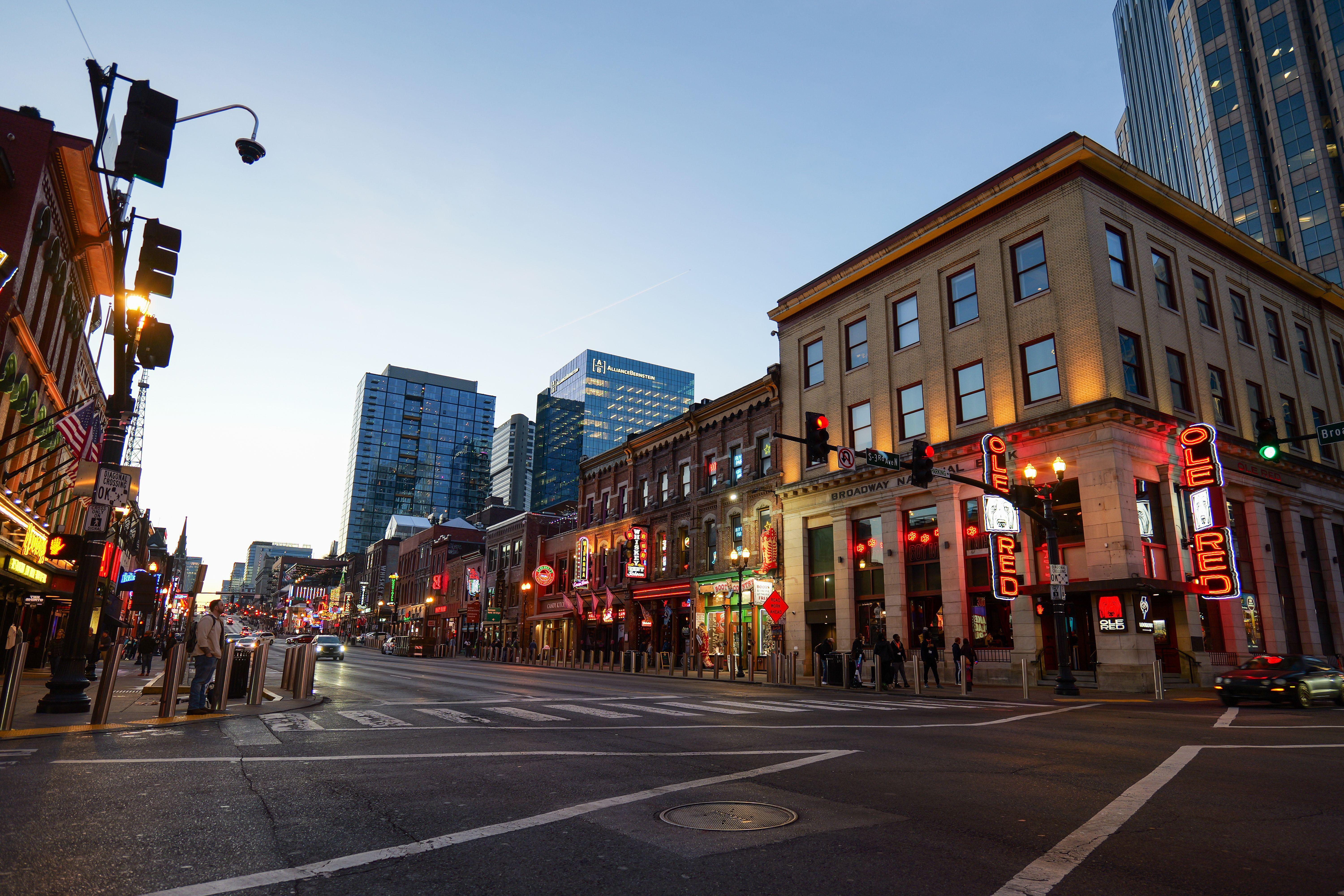 Lively street view of Nashville's Broadway, showcasing bright lights and bustling nightlife.