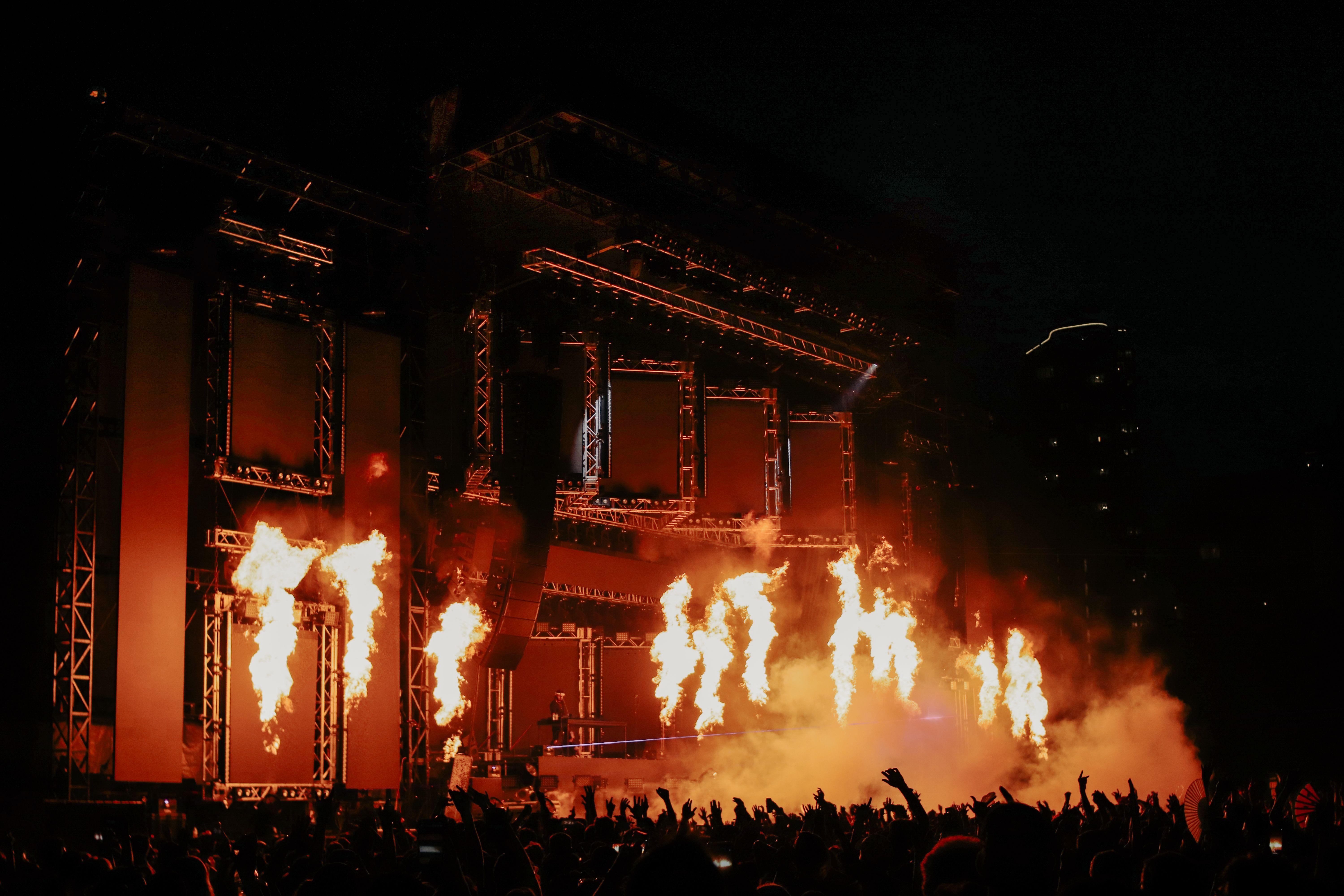 A vibrant music concert in Chicago featuring dramatic pyrotechnic flames and a lively crowd.