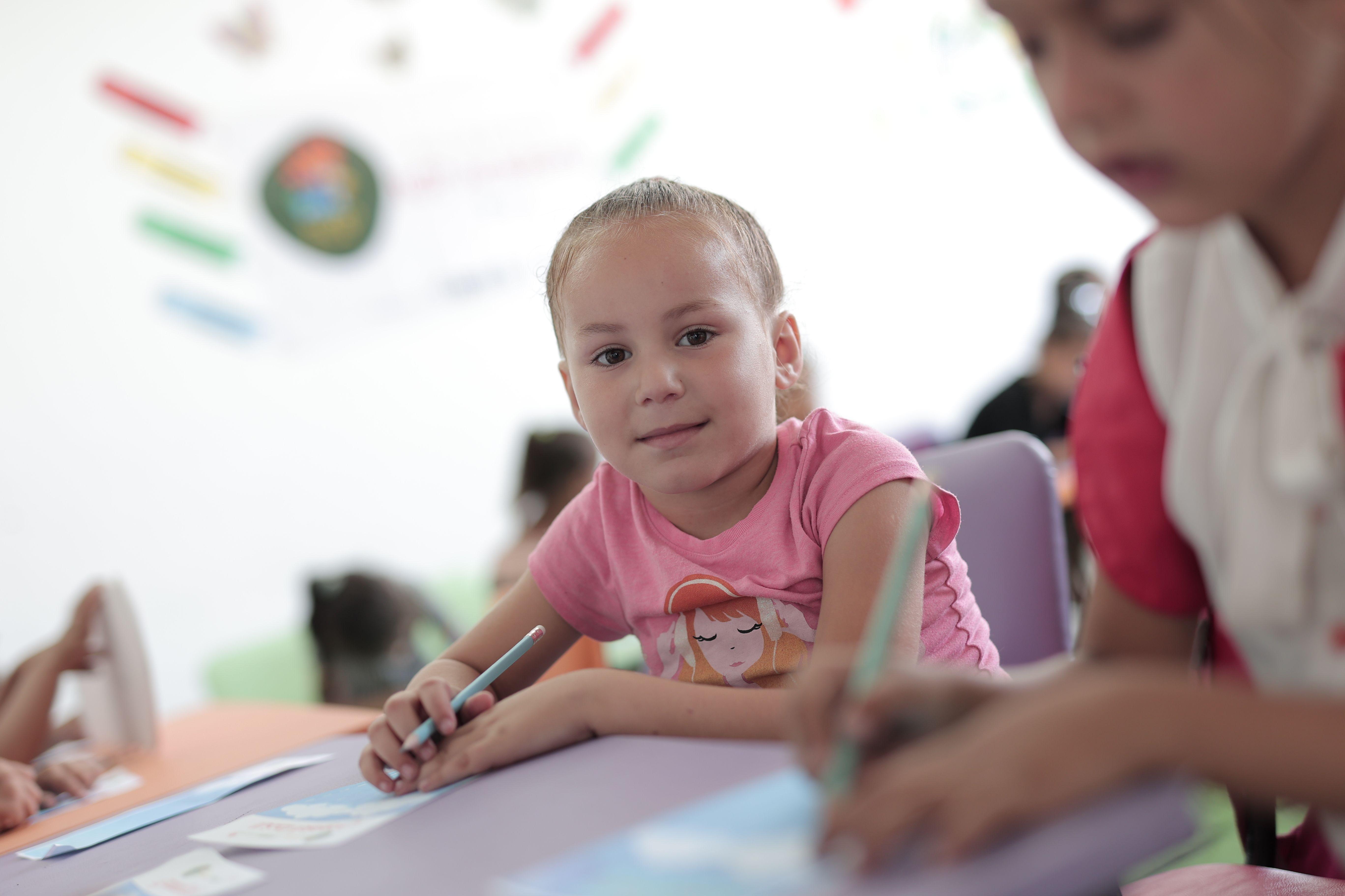 Young children actively participating in creative activities in a classroom setting, fostering learning and development.
