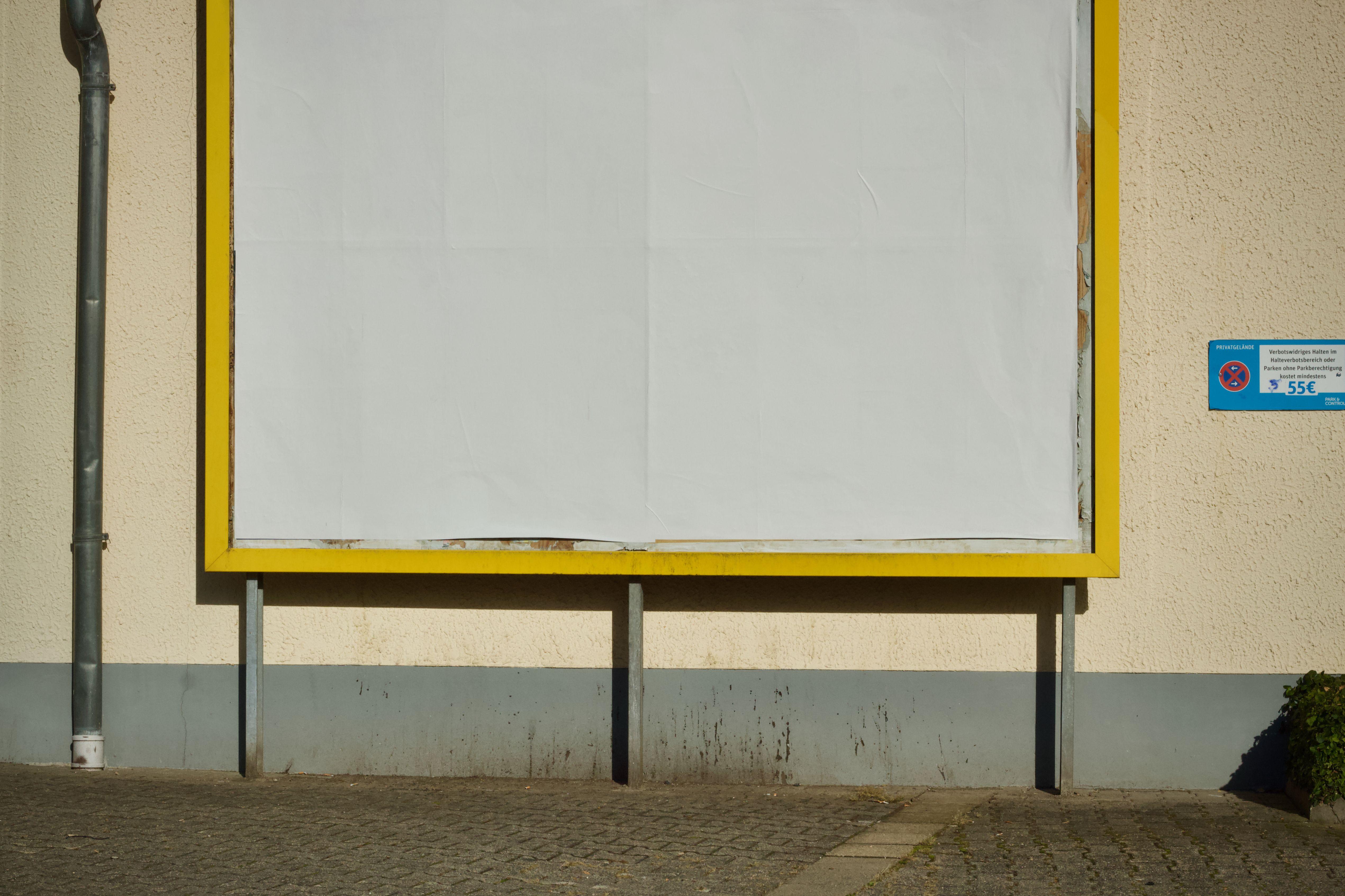 Empty billboard on a street with yellow frame, perfect for advertisement mockup.