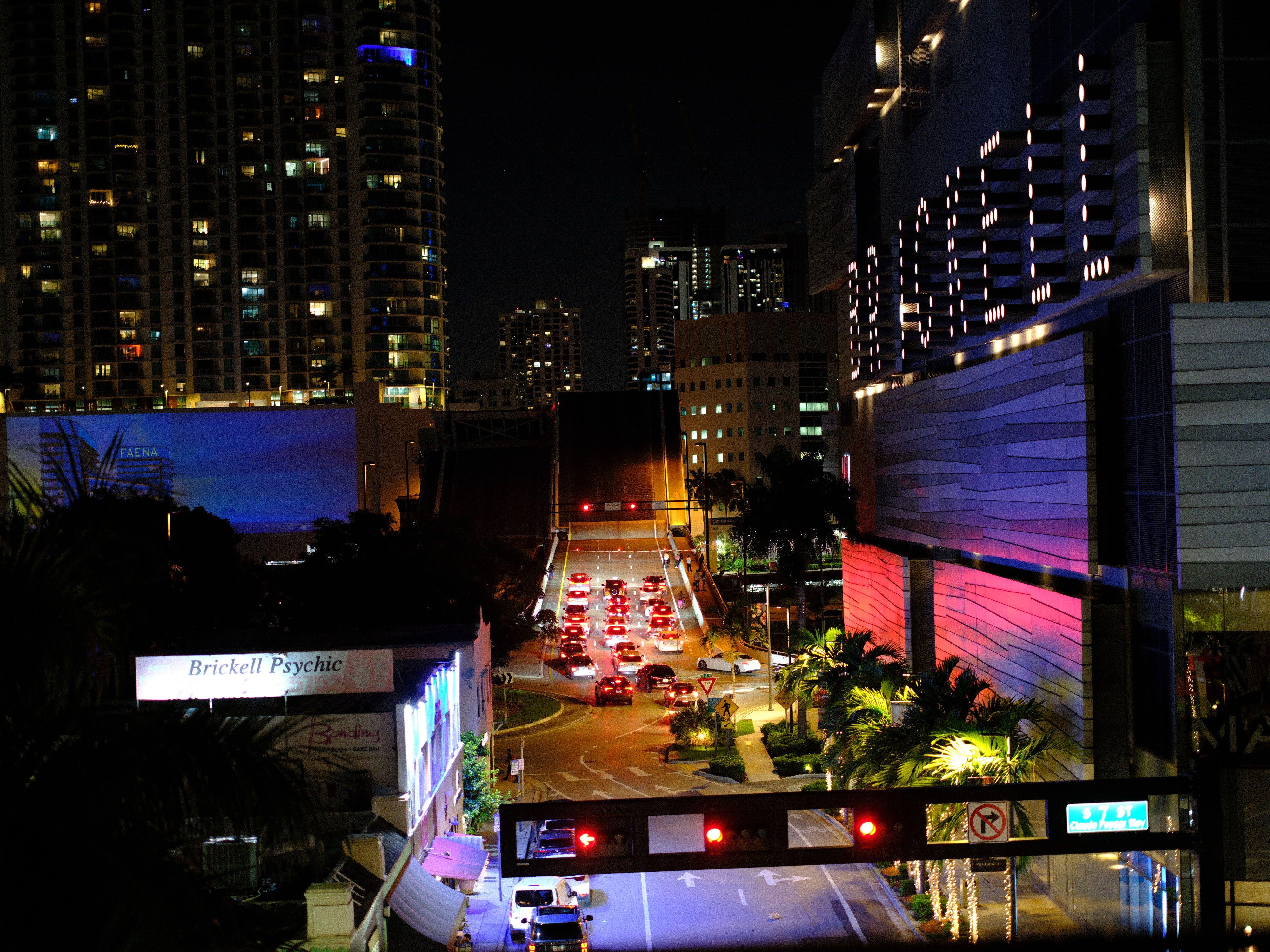 Night view of bustling Brickell with city lights, traffic, and skyscrapers.