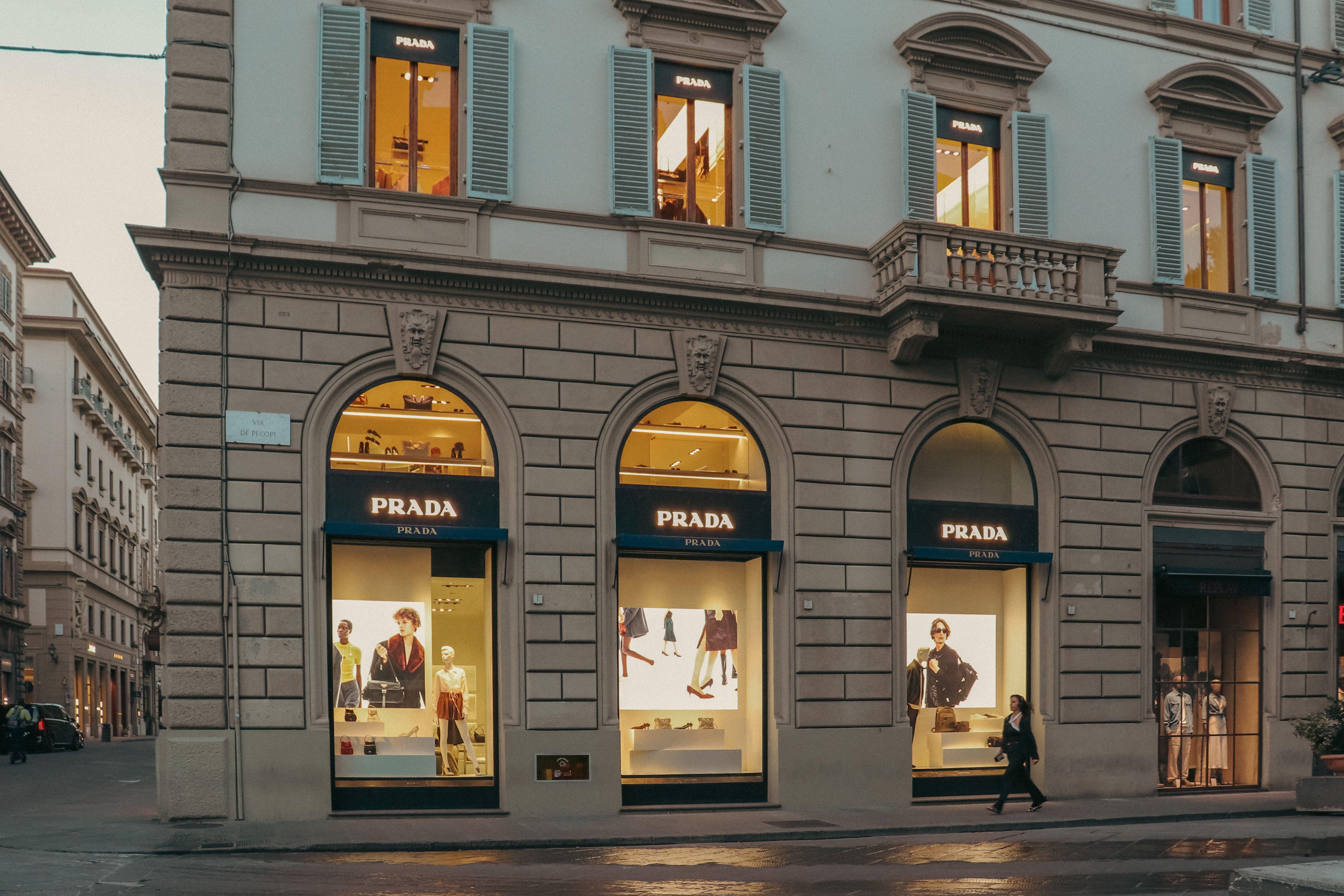 A stylish view of a Prada store facade in Florence, Italy, during evening hours.