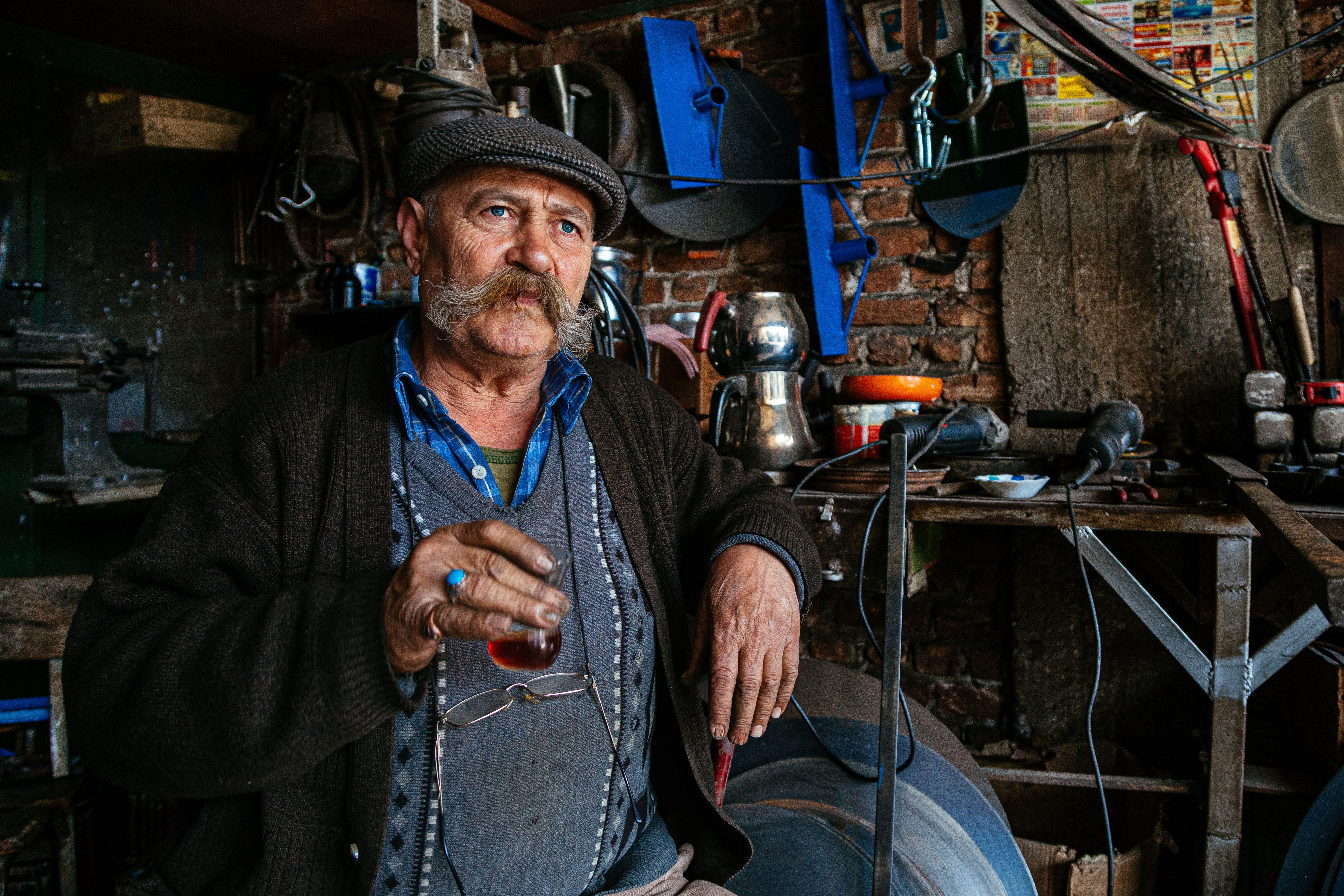Artisan enjoying tea in a traditional Denizli workshop, displaying Turkish culture.