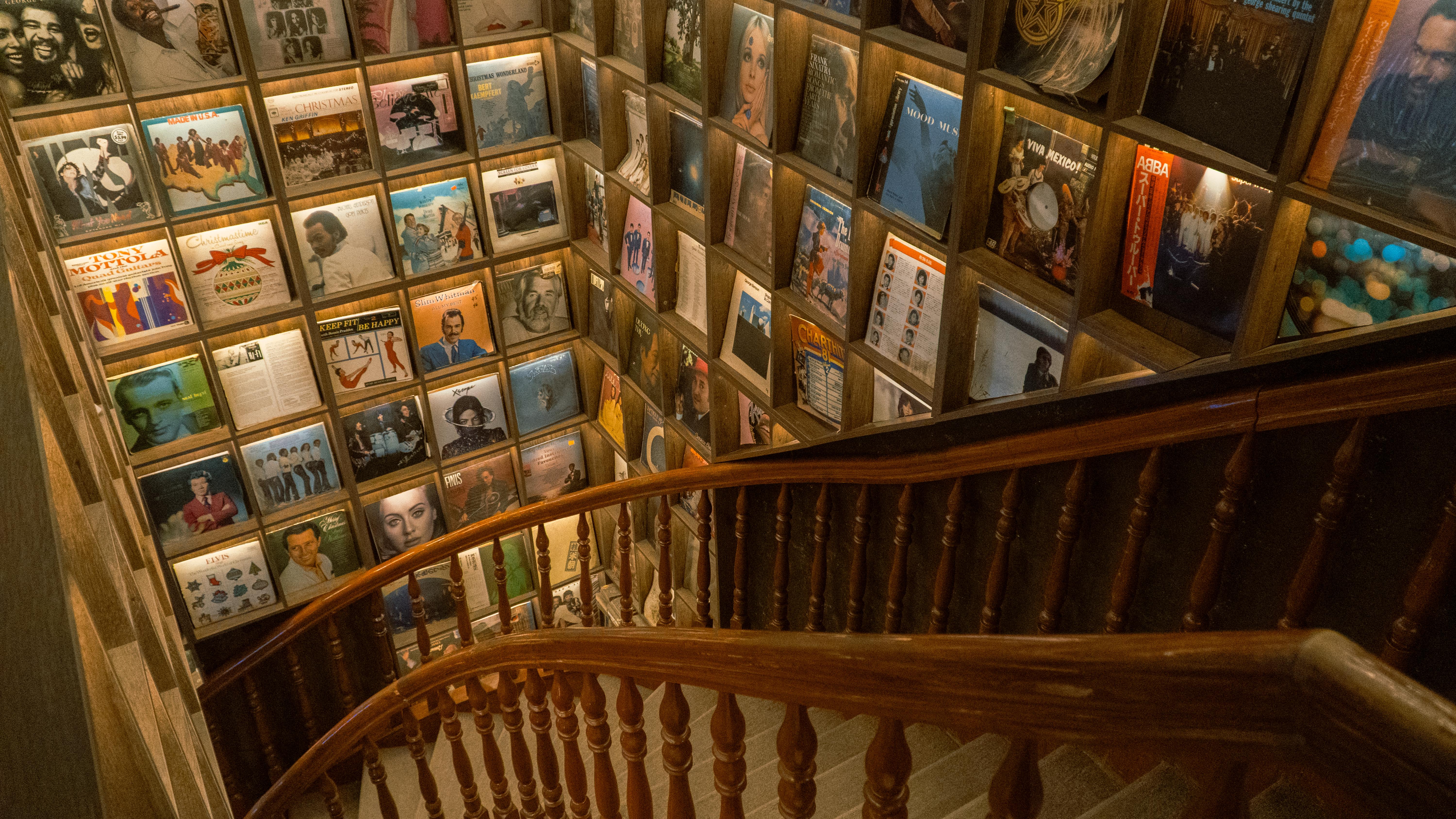 Staircase lined with vintage record albums on display, creating a nostalgic atmosphere.