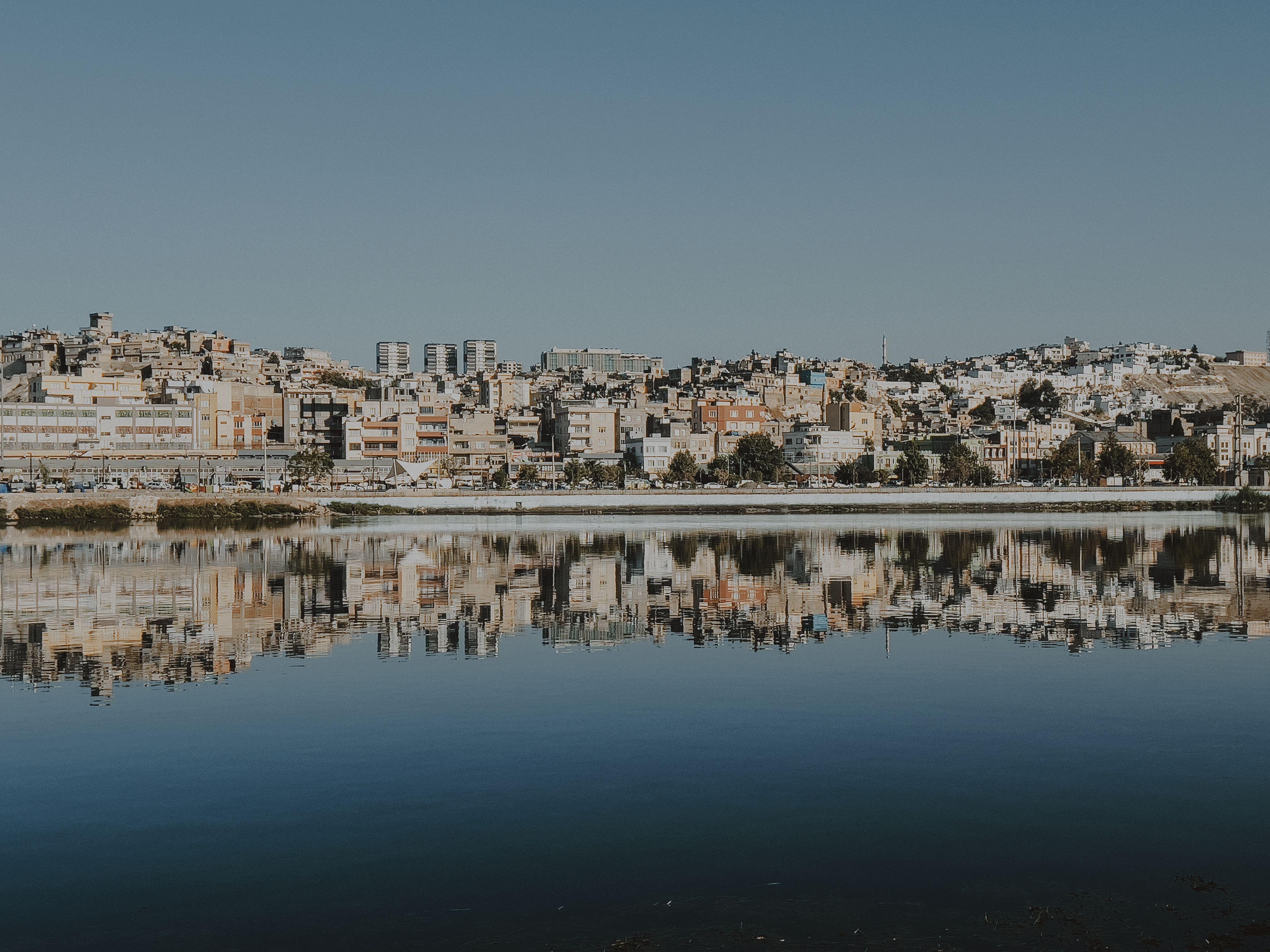 A picturesque cityscape reflecting on the calm water, showcasing urban architecture.