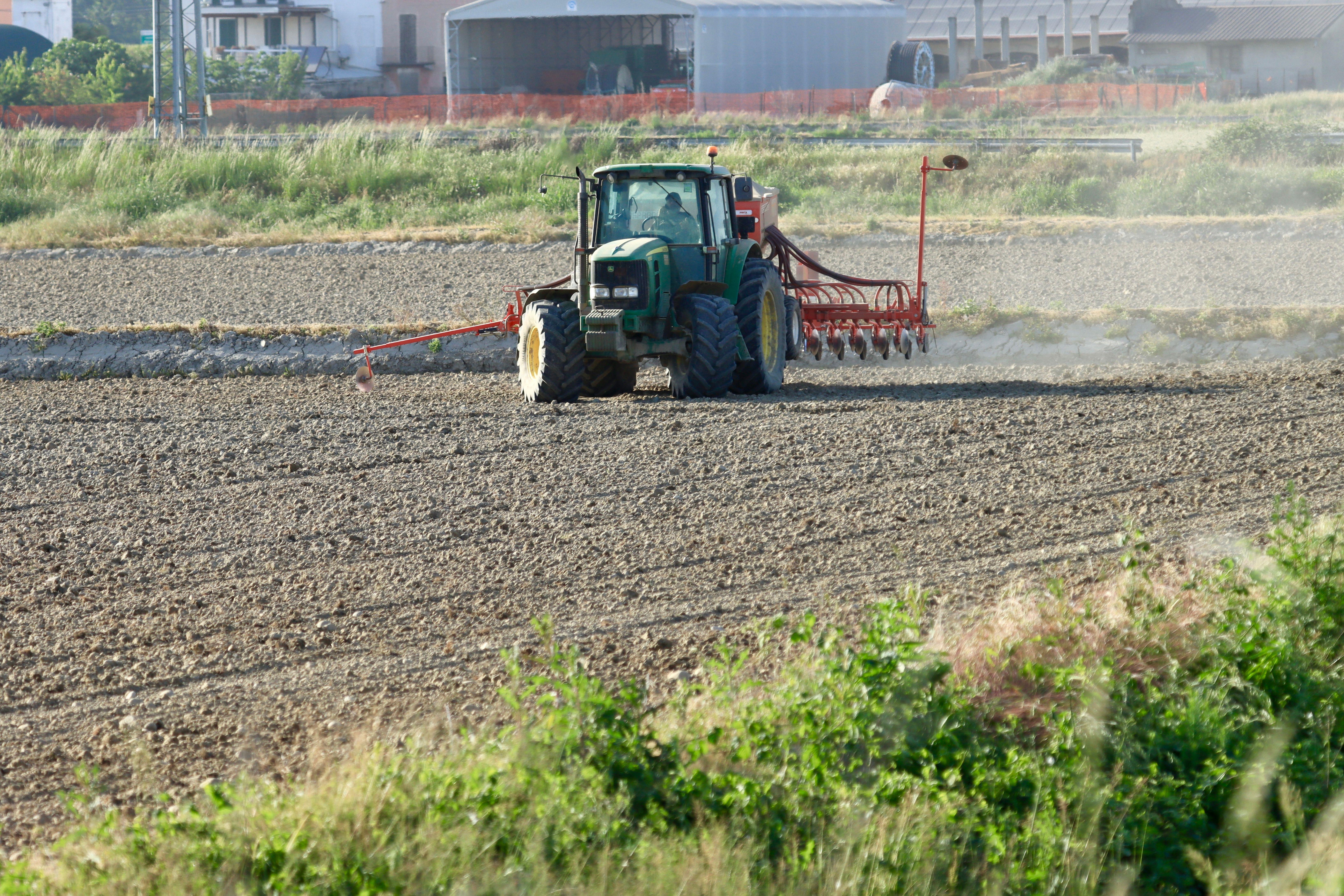 A tractor ploughing a field in Novara, Piedmont, Italy, showcasing rural agriculture.