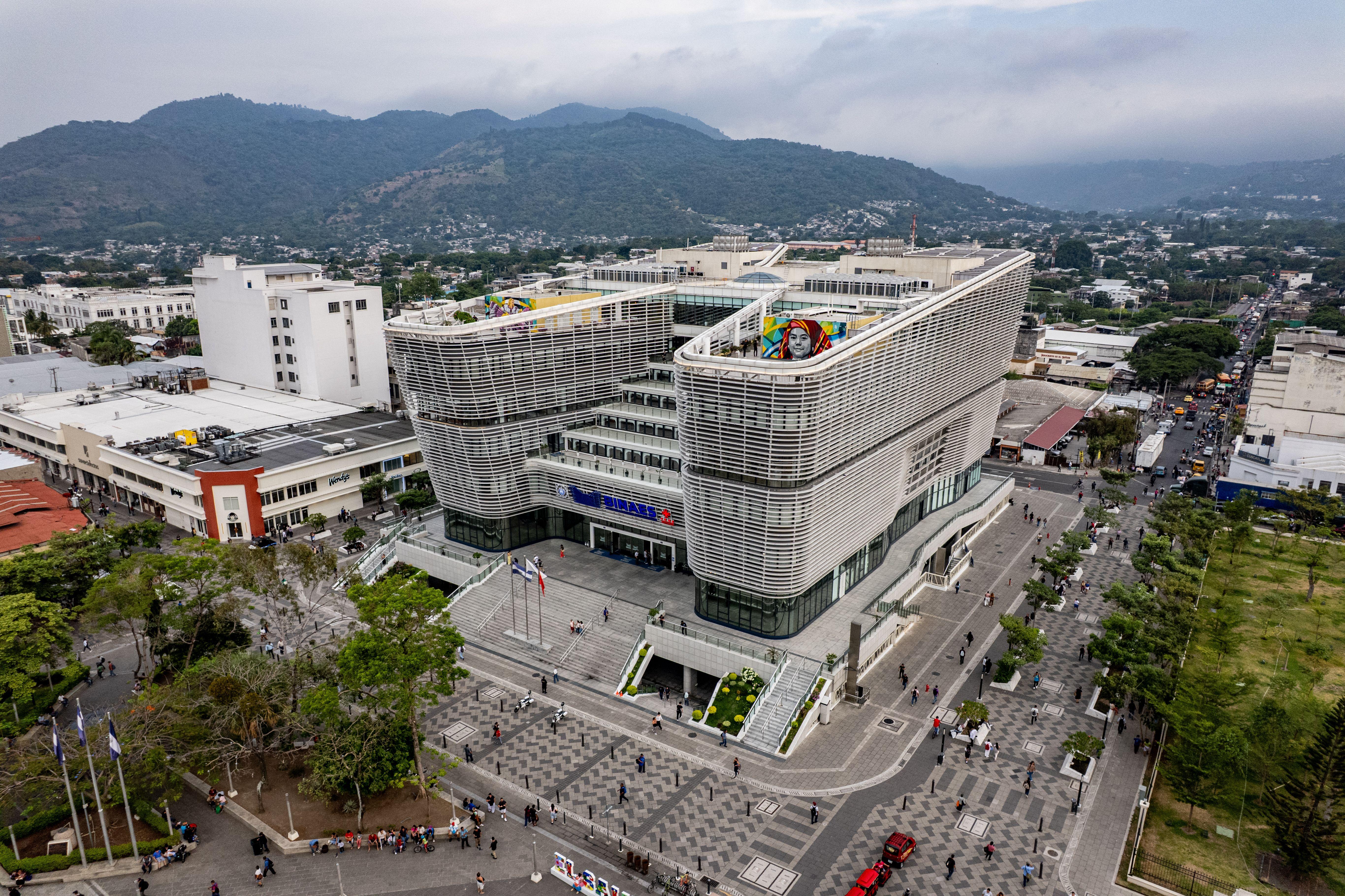 Aerial view of San Salvador's modern library and surrounding plaza with mountain backdrop.