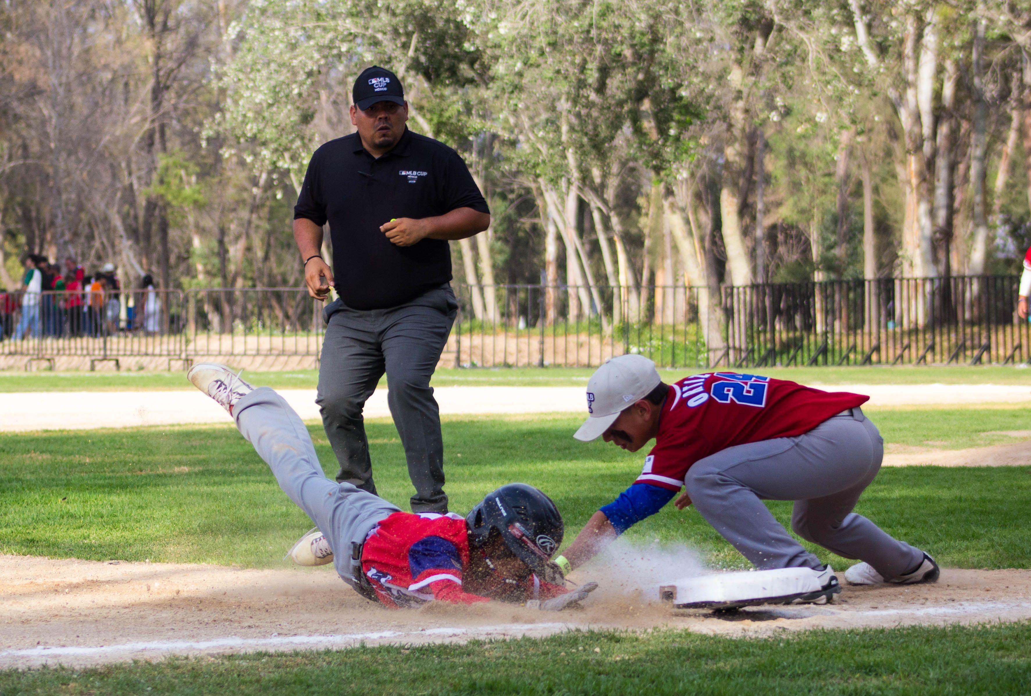 Dynamic action image of a baseball player sliding to base during a game in San Luis Potosí, México.