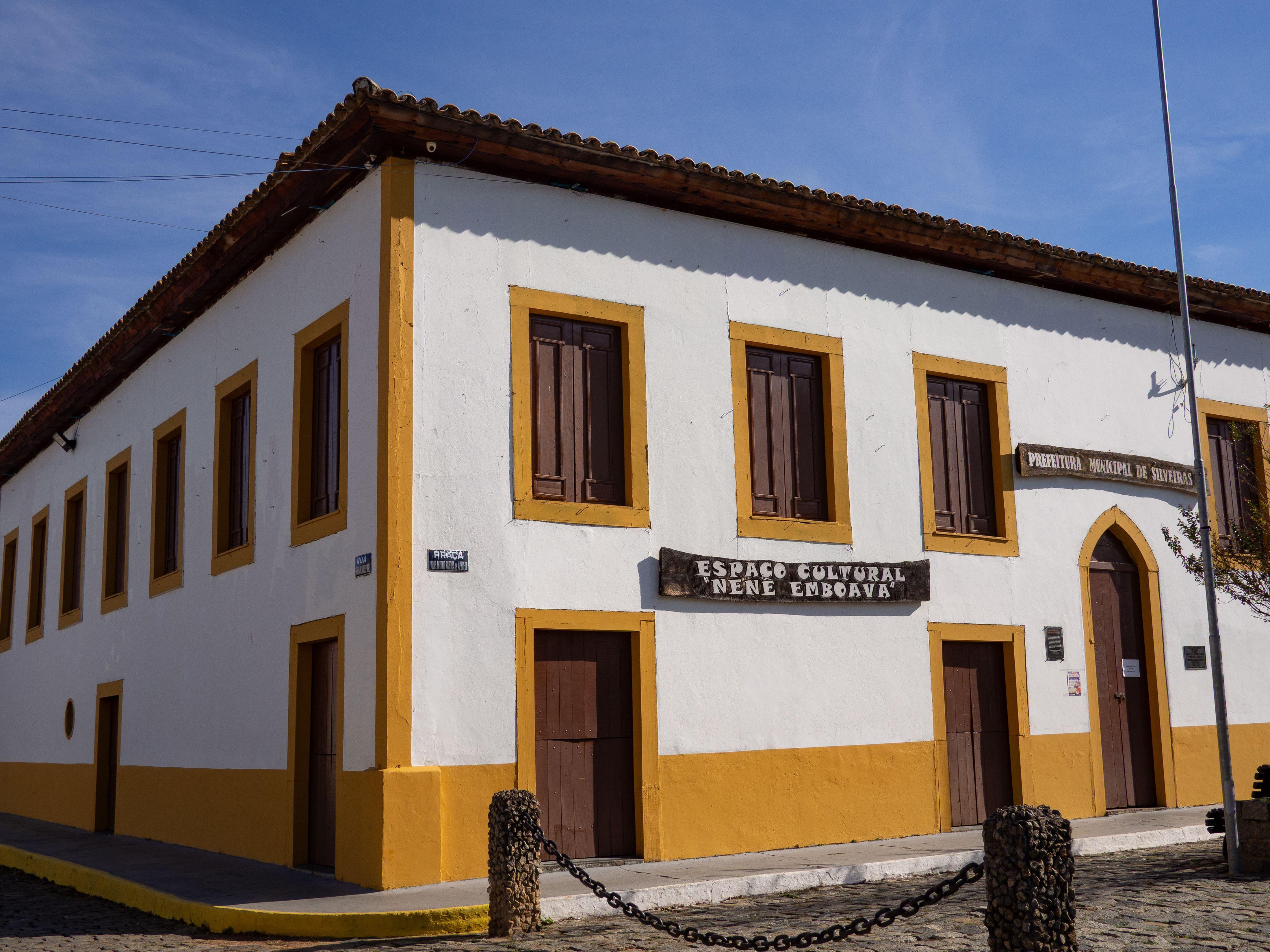 A historic building with classic rustic architecture under a clear blue sky, featuring cultural signage.