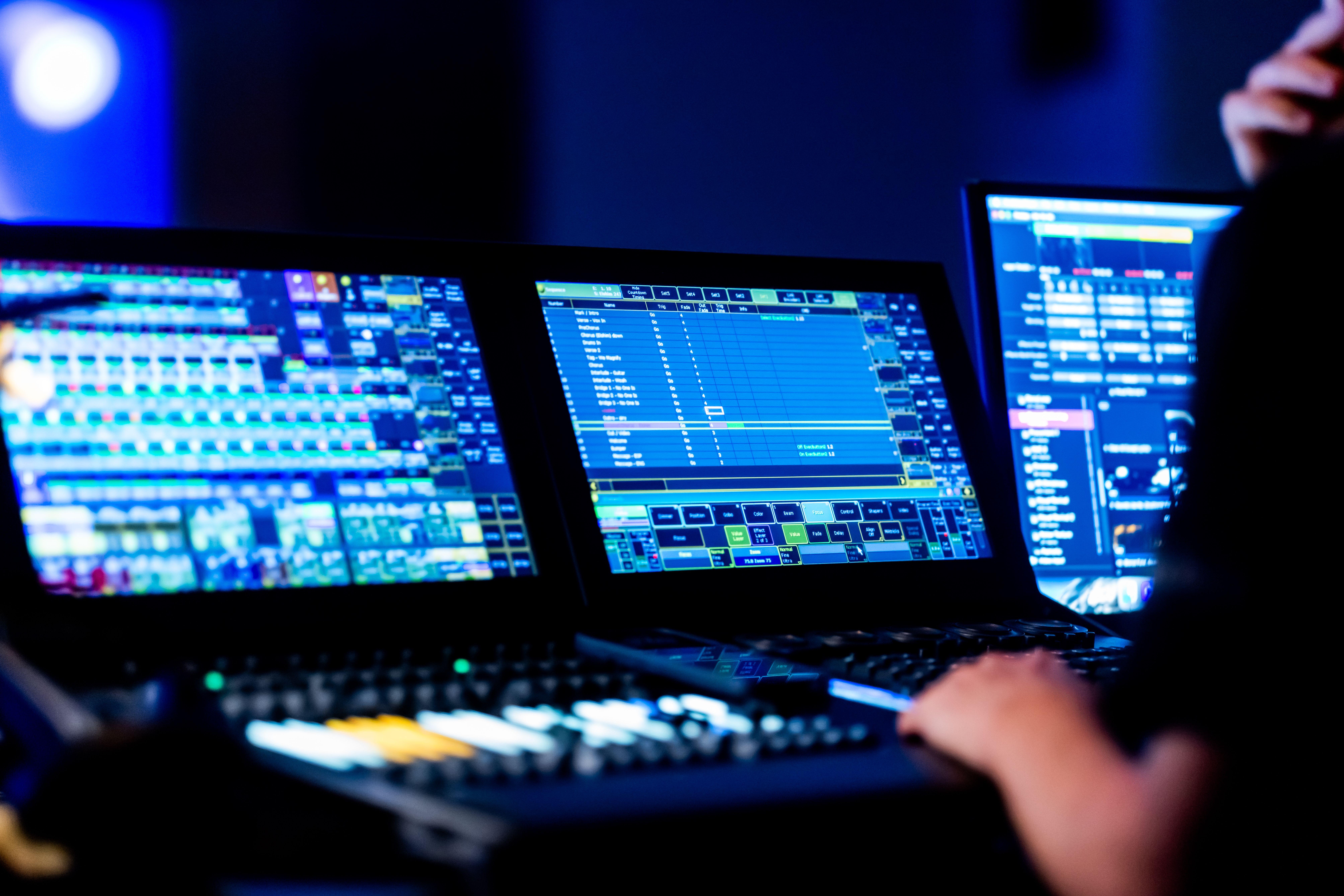 Close-up of a sound engineer using a digital mixing console during a live event.