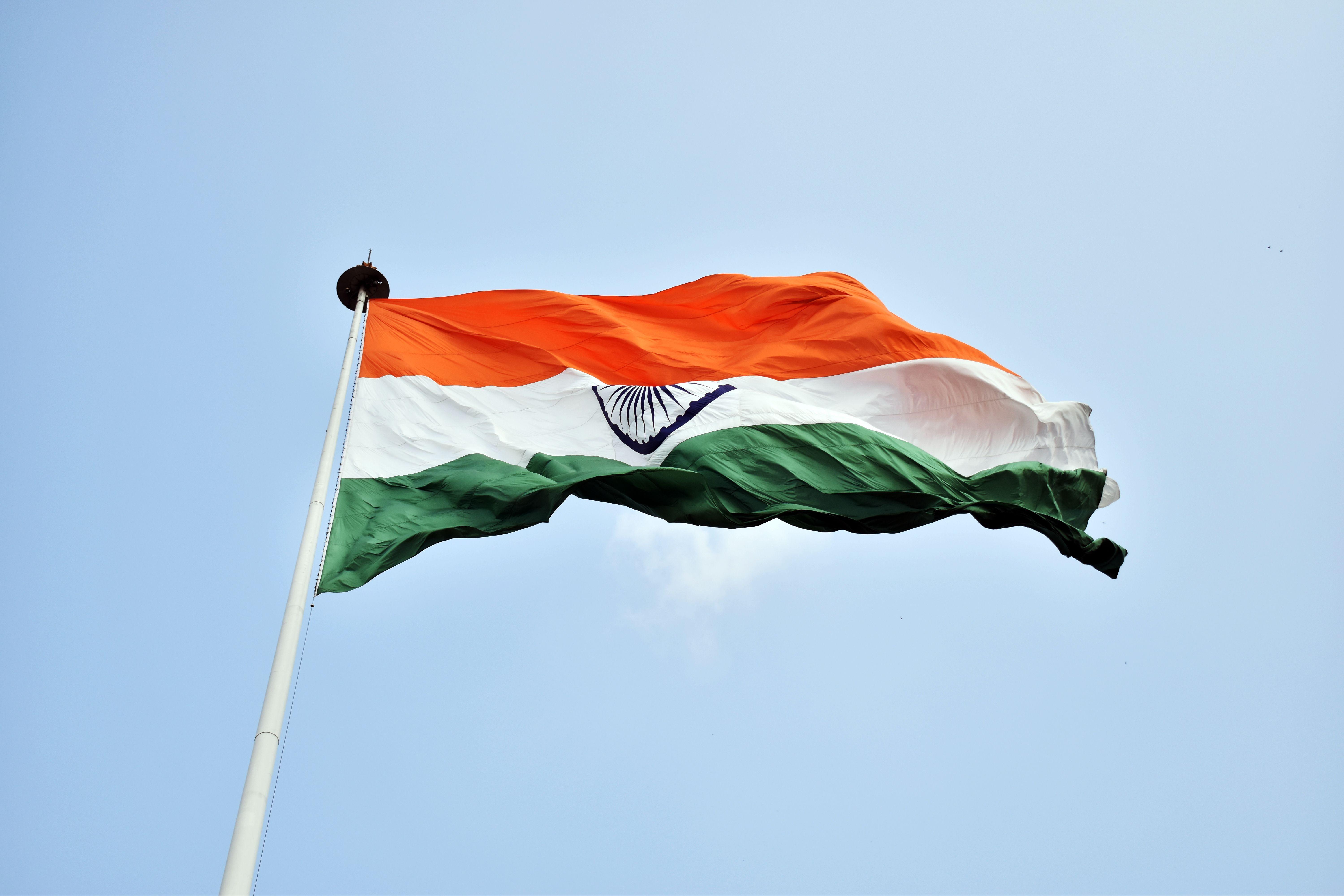 The Indian national flag waves proudly against a clear blue sky in New Delhi.