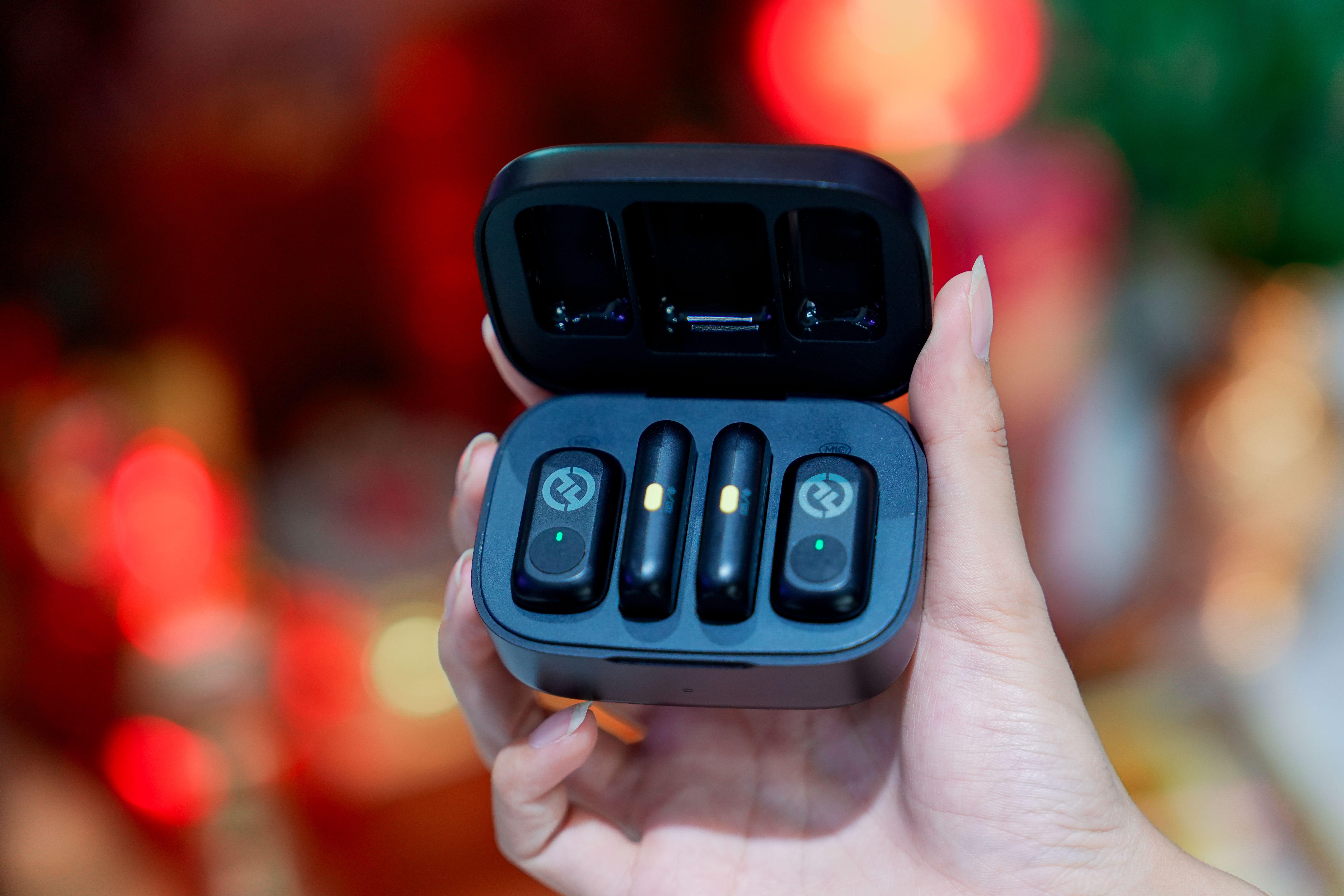 Hand holding wireless earbuds case with modern design, perfect for technology and gadget enthusiasts.