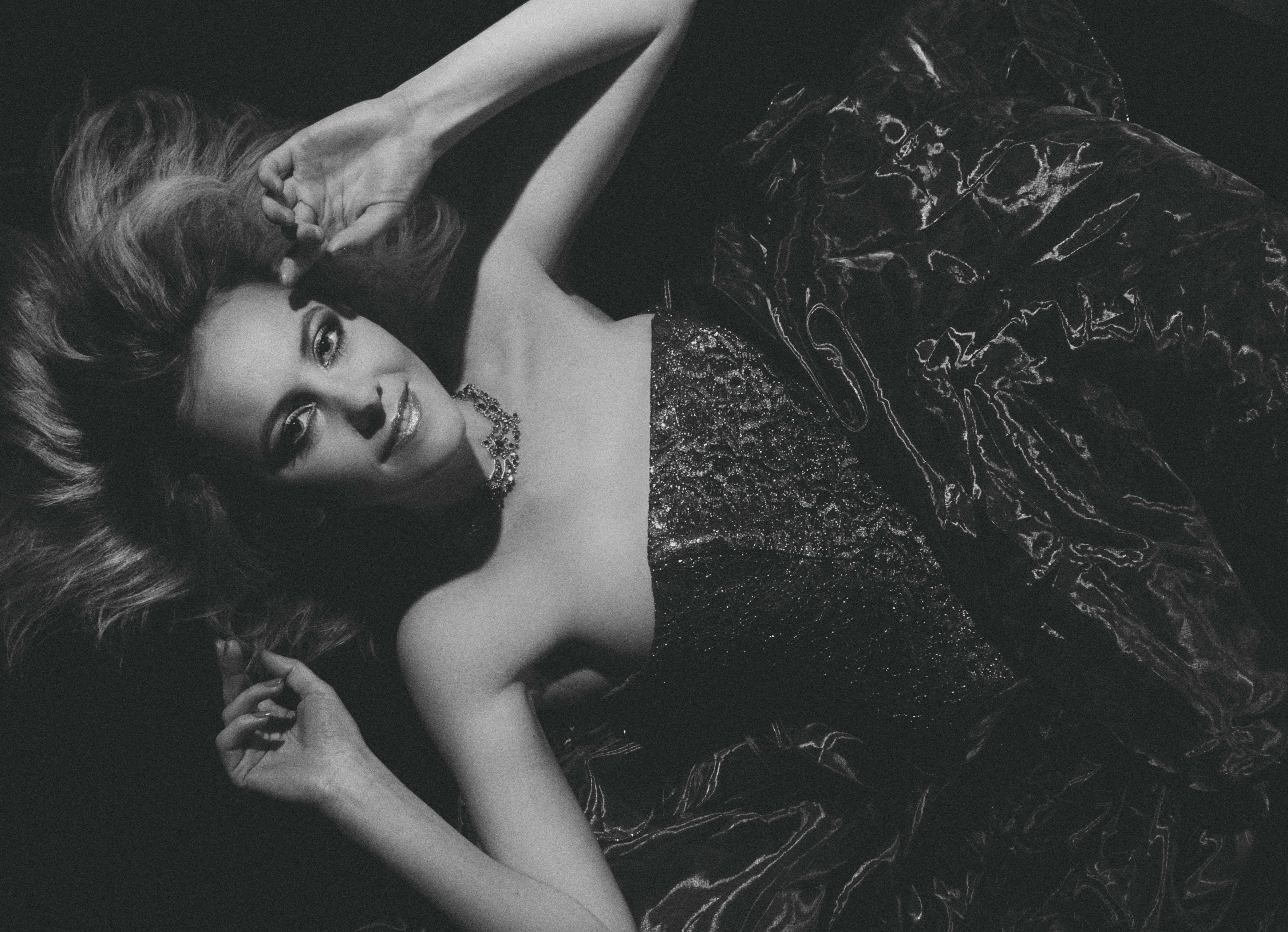 A timeless black and white studio portrait capturing elegance and glamour in exquisite monochrome.