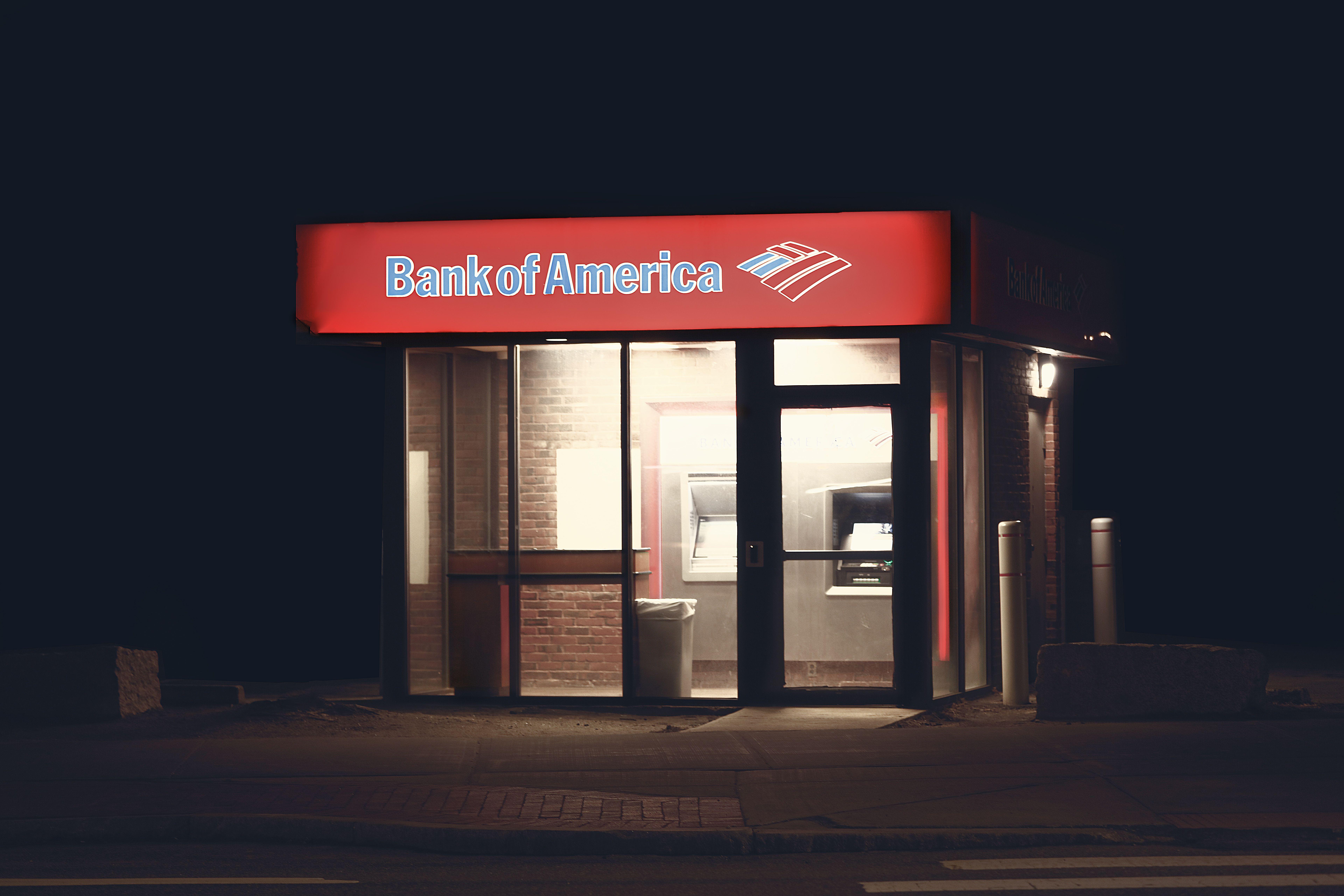 Illuminated Bank of America ATM structure against a dark nighttime backdrop in Boston.