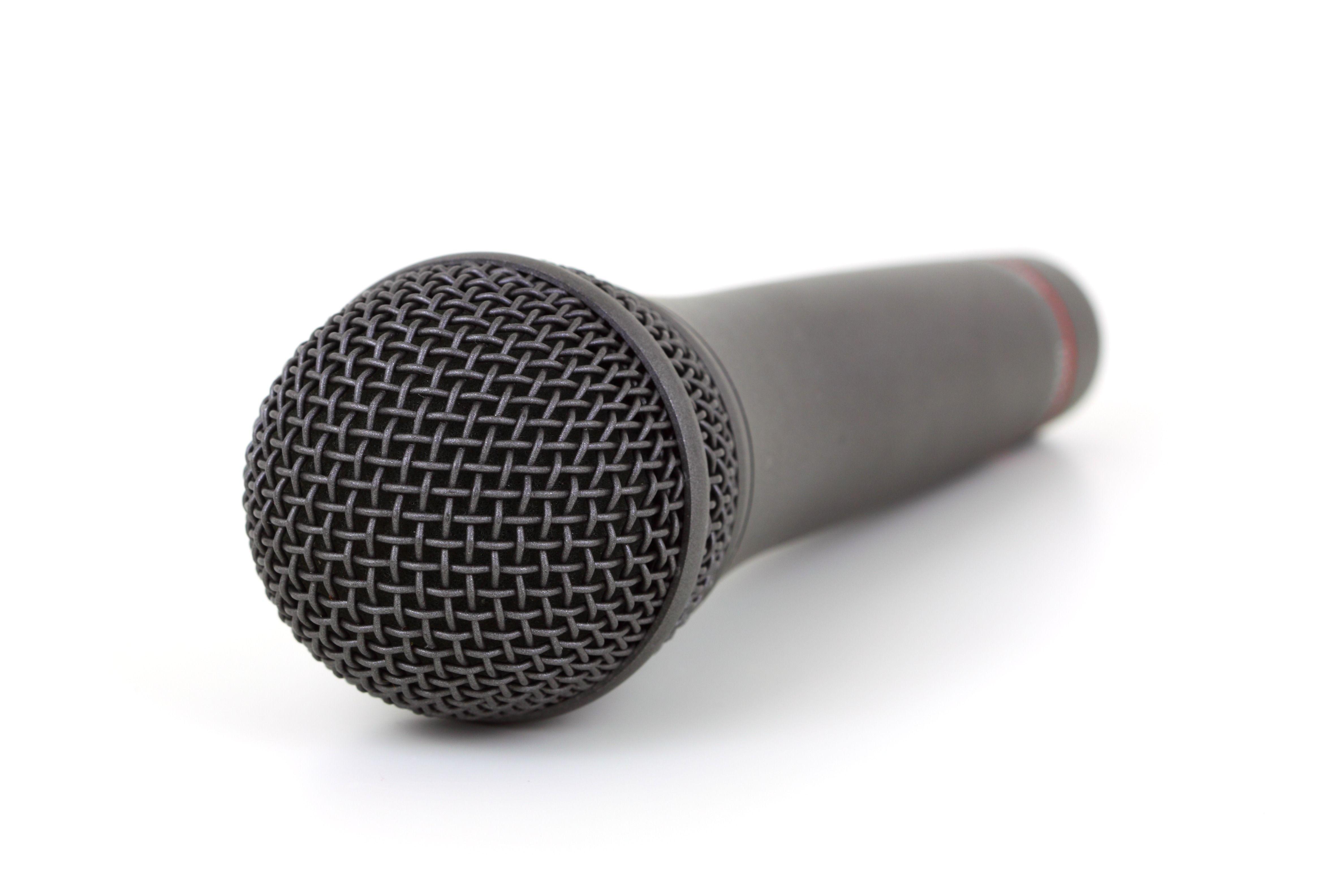 Close-up of a black microphone on a white background, ideal for audio equipment themes.