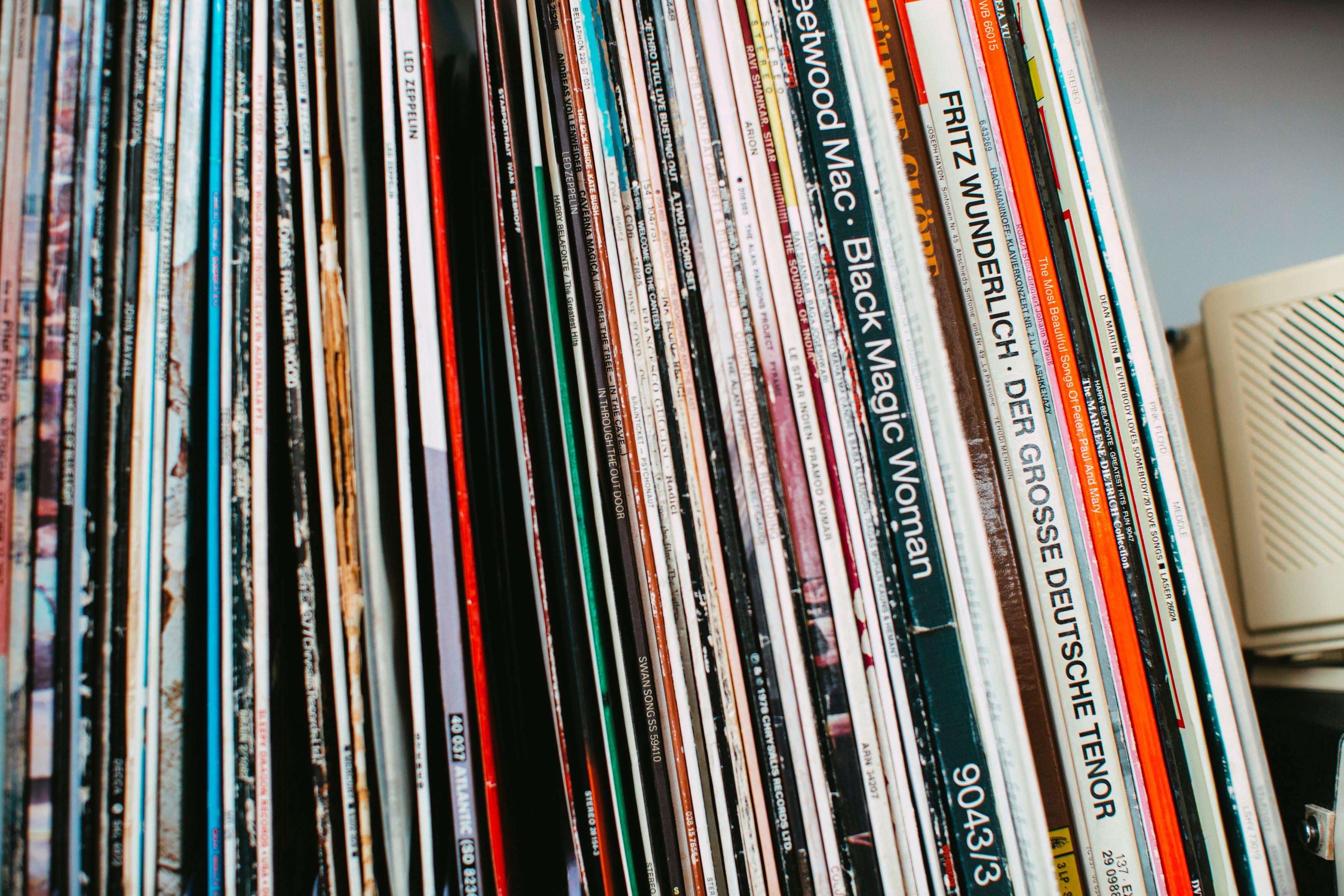 Stack of classic vinyl records neatly arranged on a shelf indoors.