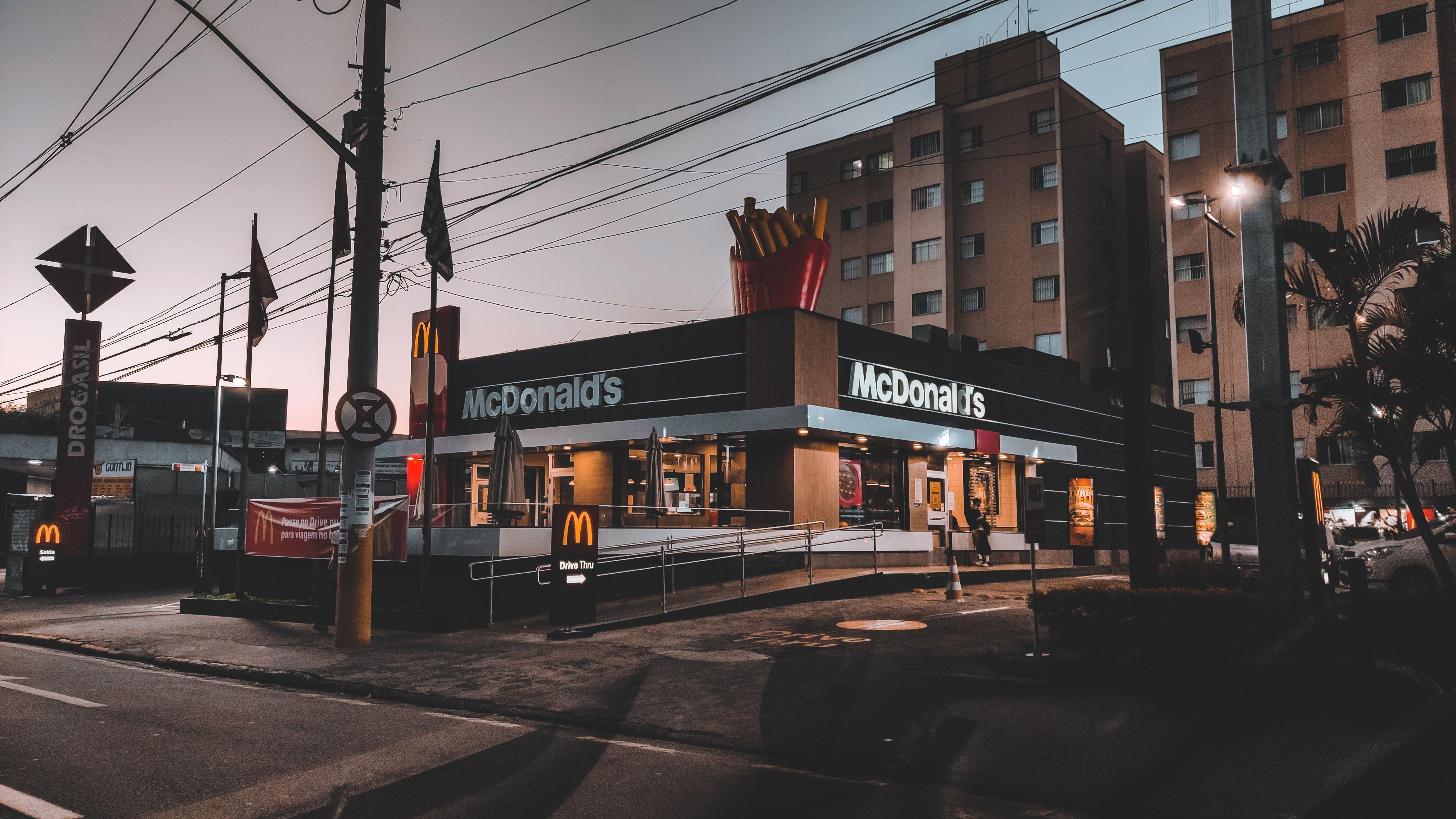 Exterior of modern residential buildings located in suburb near road with signboards and banners and fast food restaurant