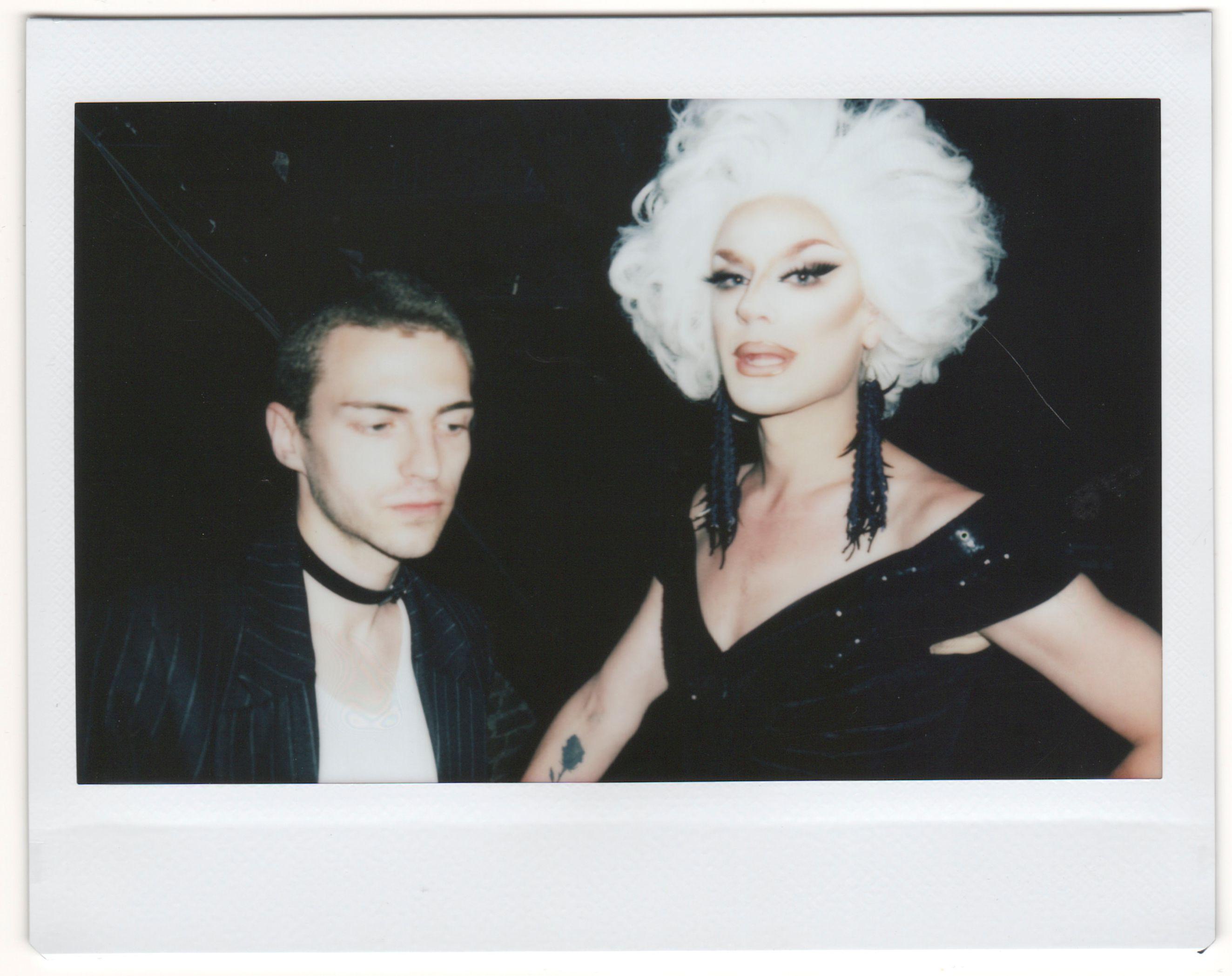 Vintage polaroid photo of a drag queen and a person at a nightclub party.