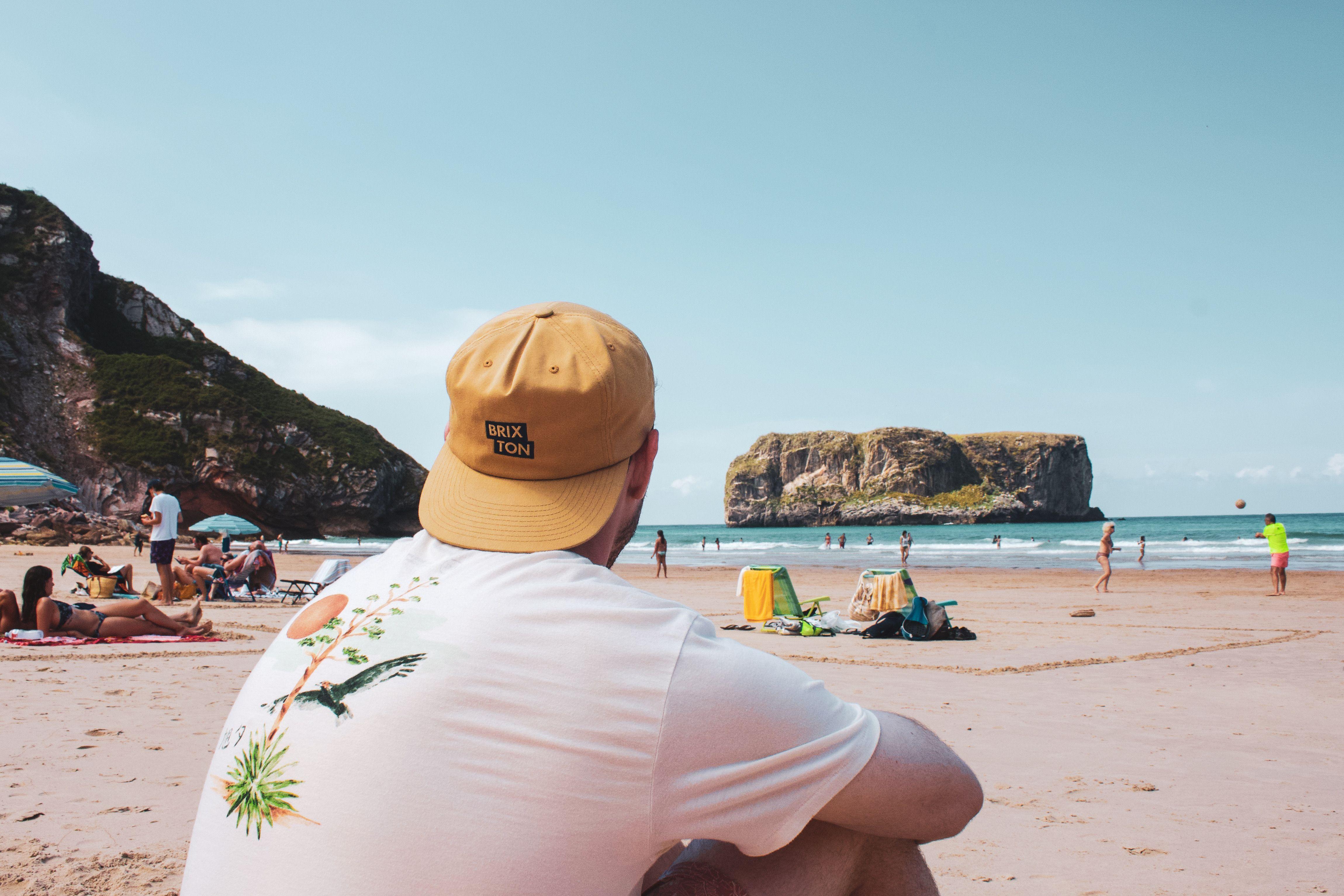 Man enjoying a sunny day at Gulpiyuri Beach, Asturias, Spain. Perfect for beach lovers.